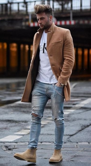 White t-shirt with ripped denims and light brown long overcoat and brown boots_