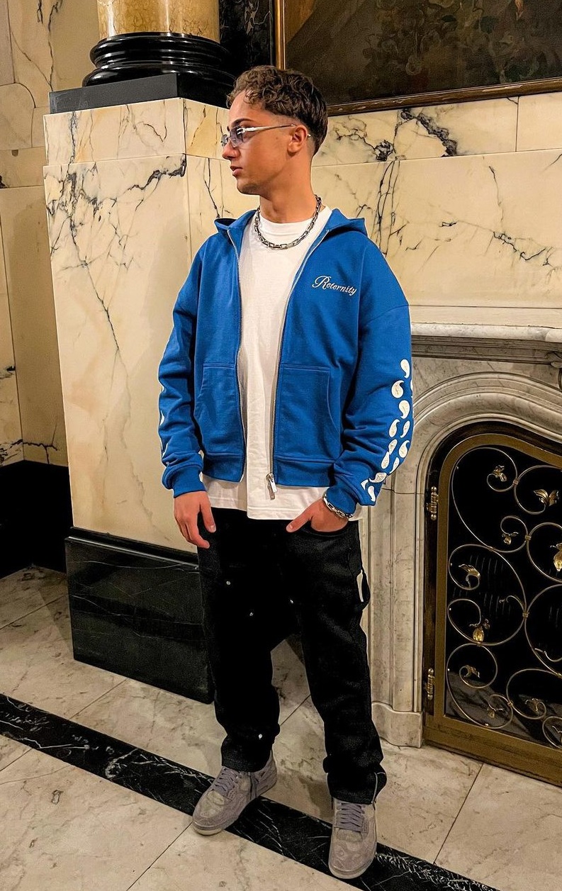 white t-shirt with blue jacket and black joggers with shoes