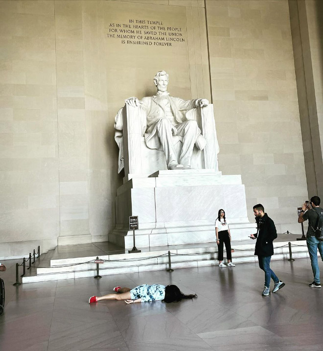 Artist pretends to be dead at various locations.