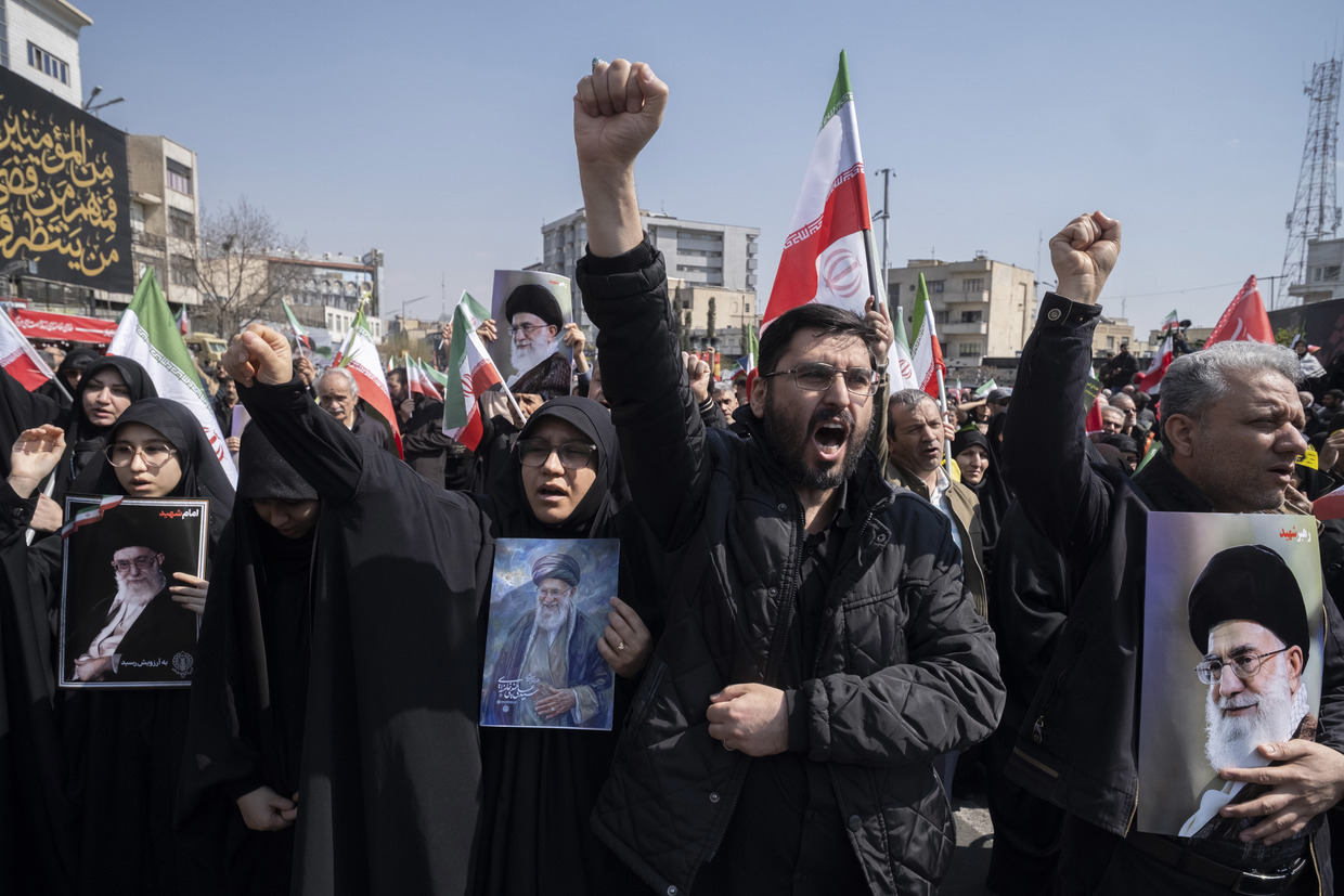 Iranian mourners hold portraits of Ayatollah Ali Khamenei during a funeral for Ali Larijani and other top security officials in Tehran, Iran, March 18, 2026