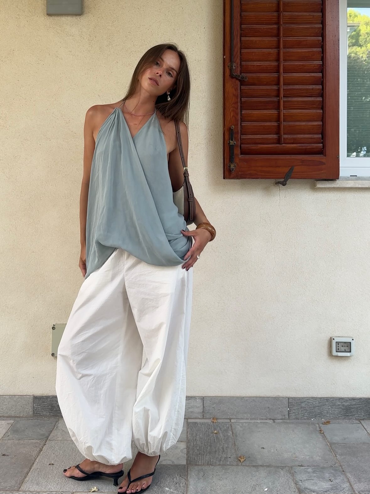An image of @johannalager wearing heeled flip-flops with balloon trousers and a halter-neck top.