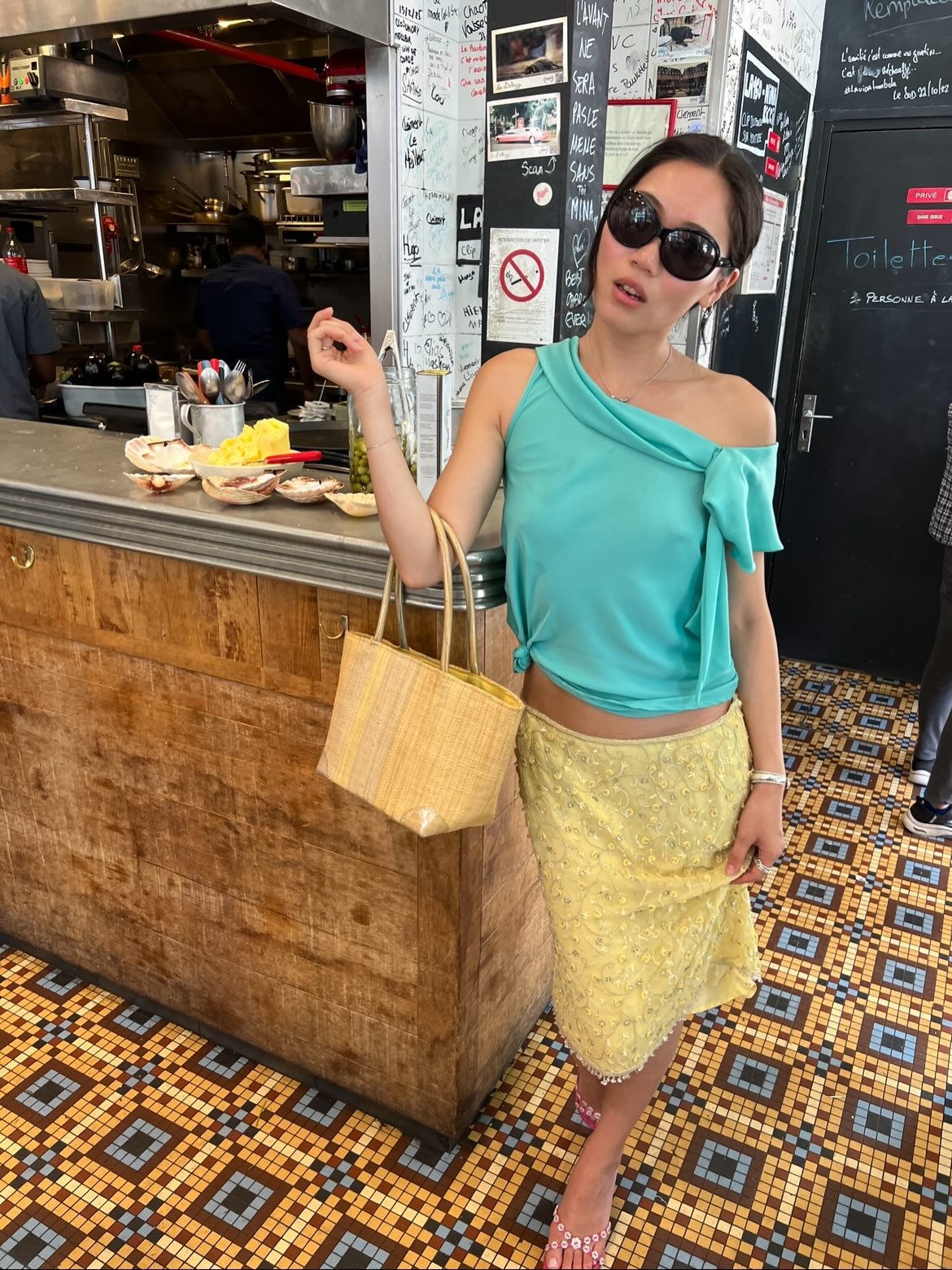 Woman in a turquoise top and yellow skirt