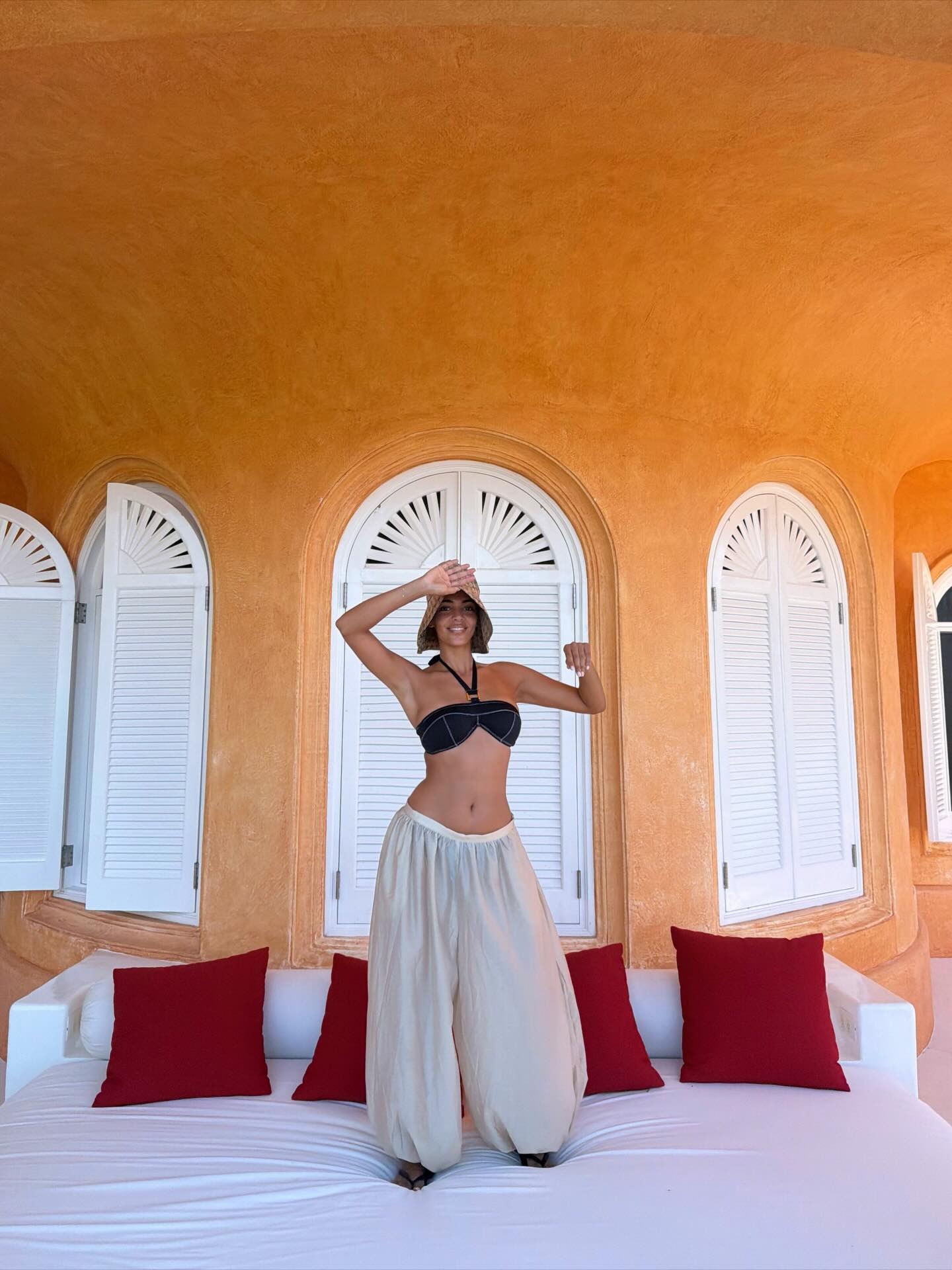 @sandrashehab wearing a black bikini top with genie pants.