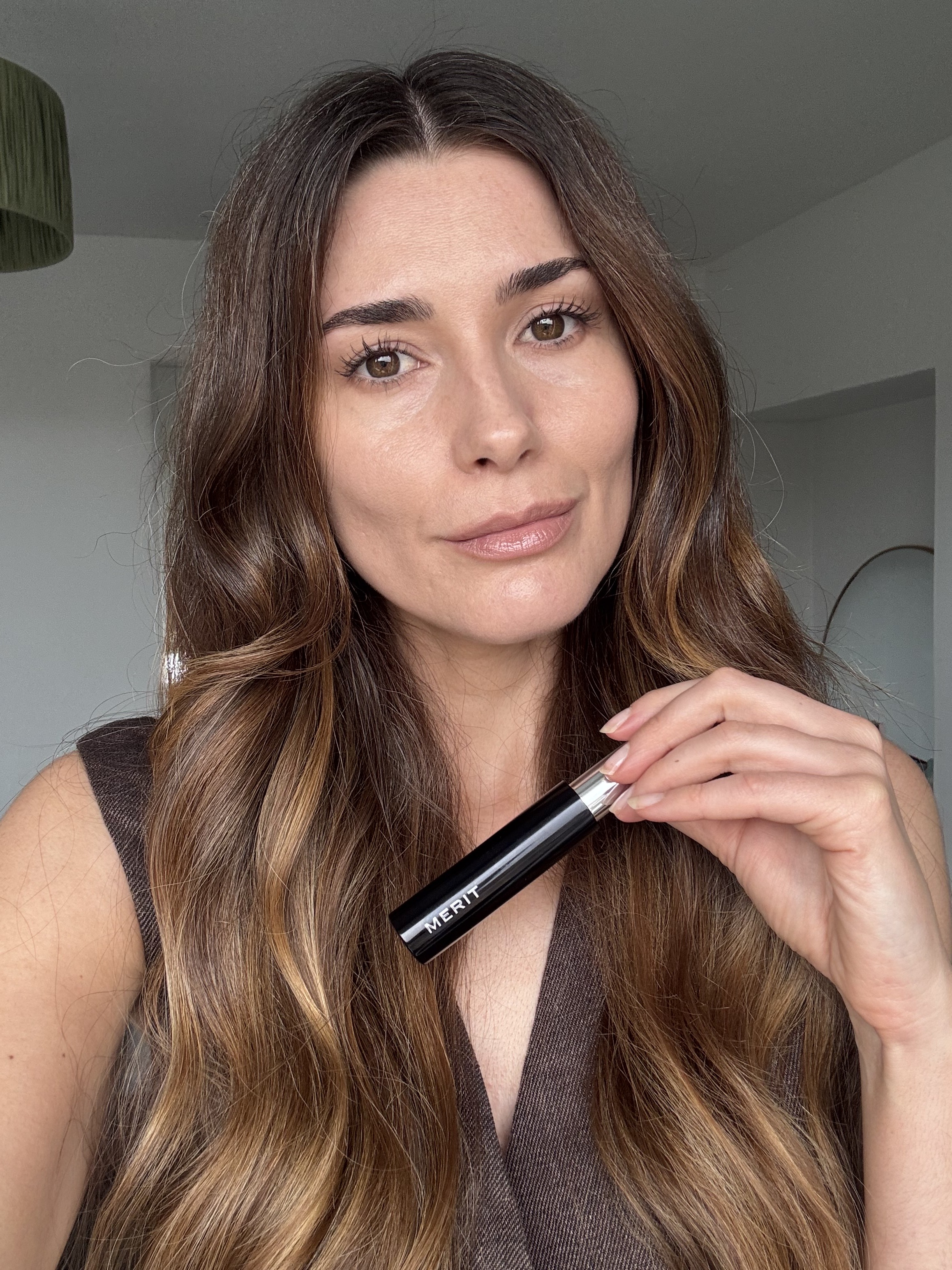 Eleanor holding a tube of Merit Clean Volume Mascara