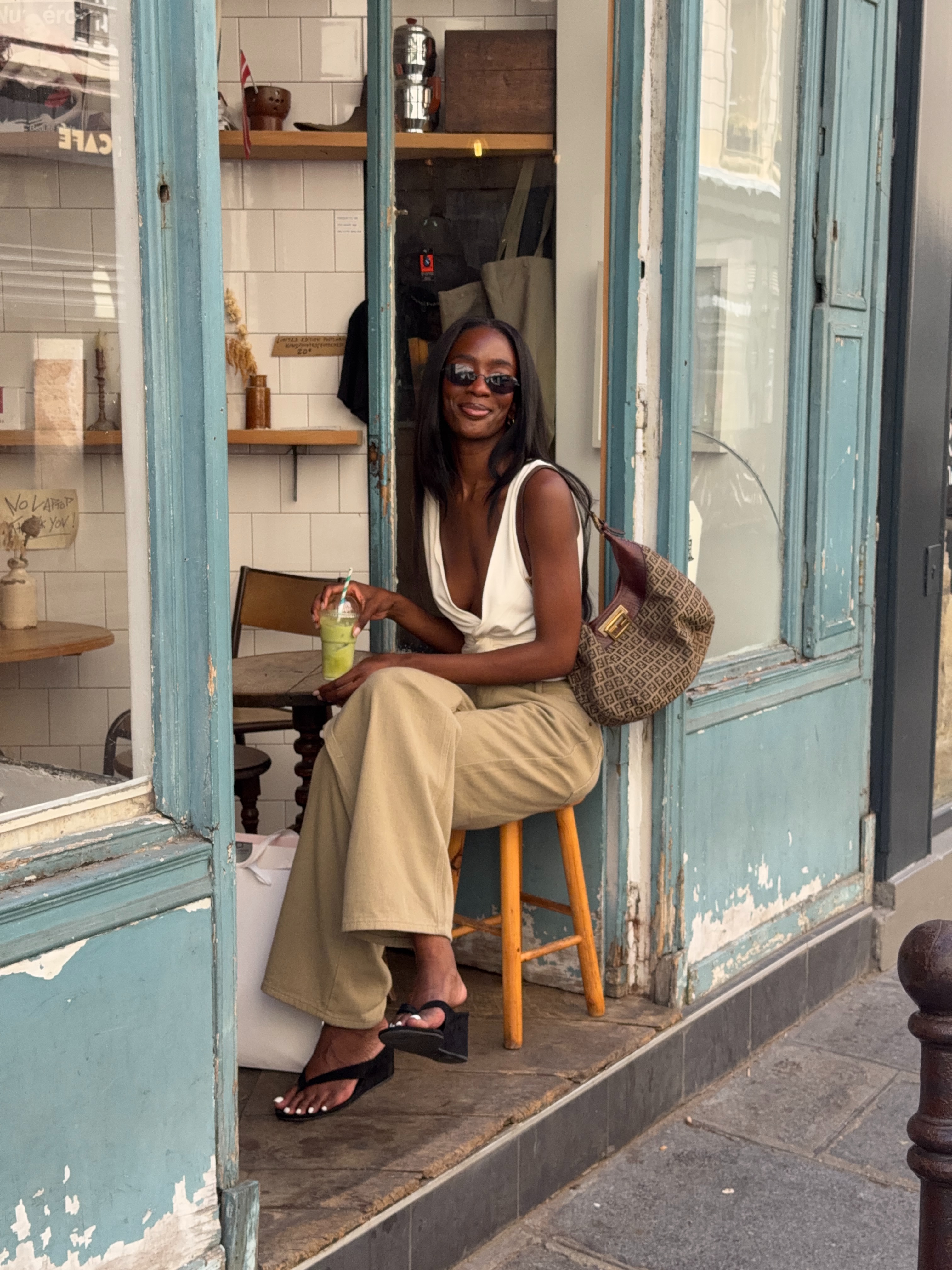 An image of @_livmadeline wearing khaki jeans with heeled flip-flop wedges and a white top.