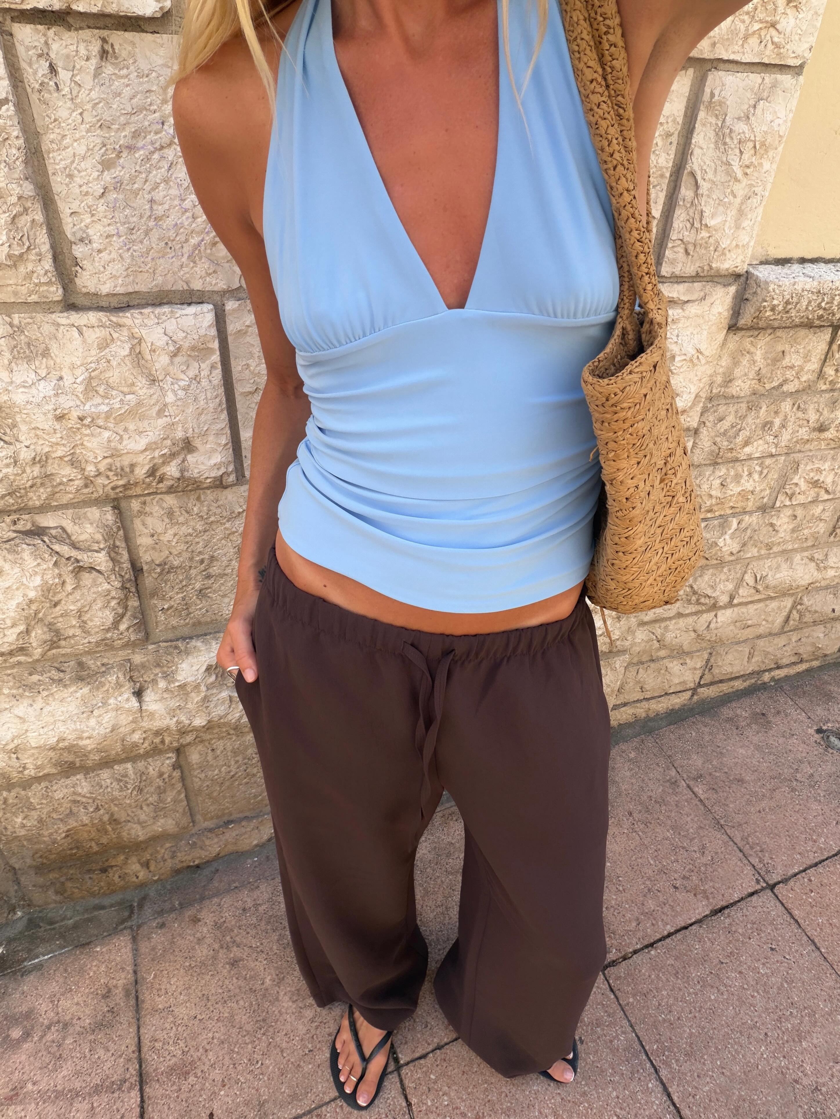 Woman in pale blue and brown pants