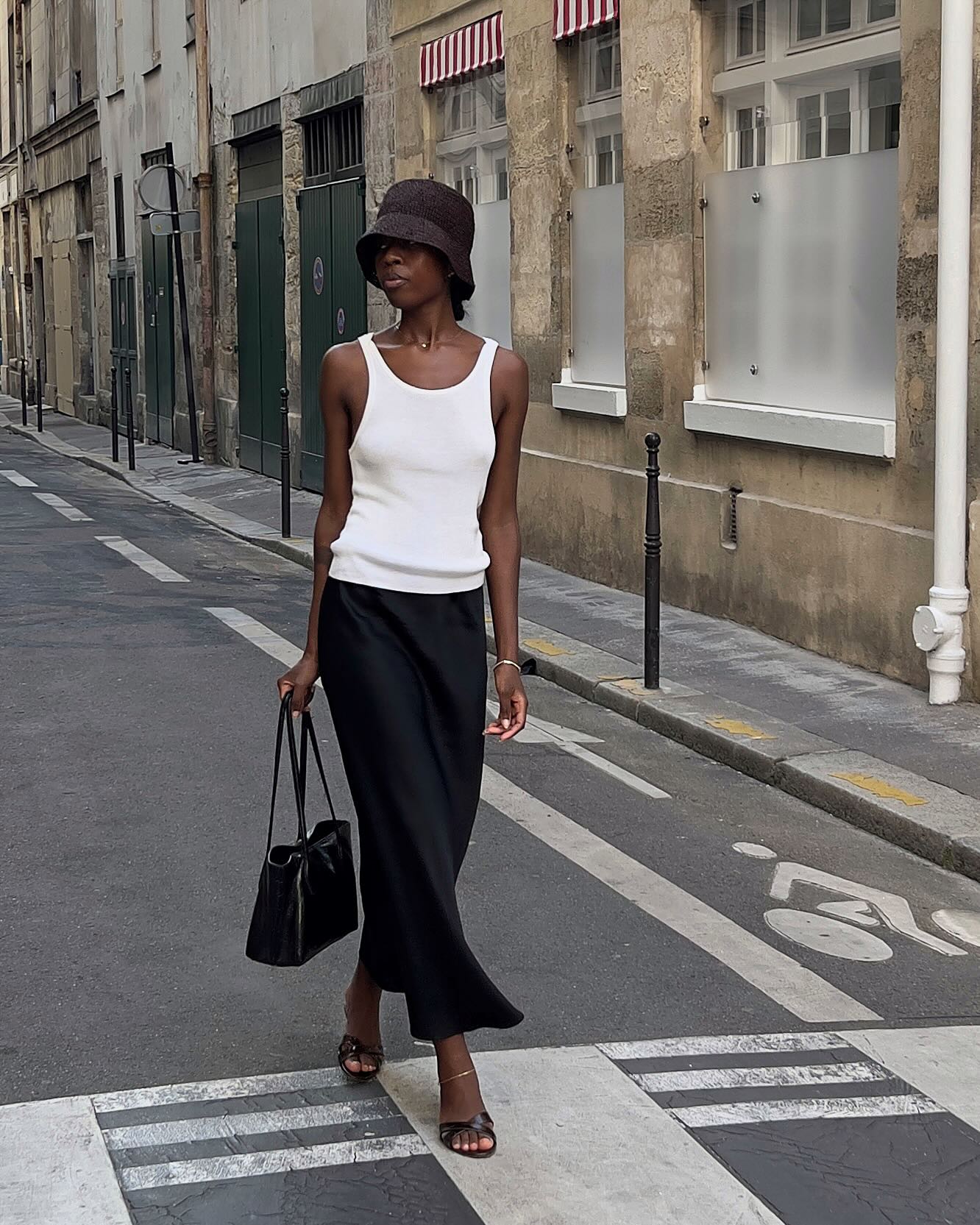 An image of @sylviemus_  wearing a white tank top, one of the best '90s summer trends coming back in 2026.