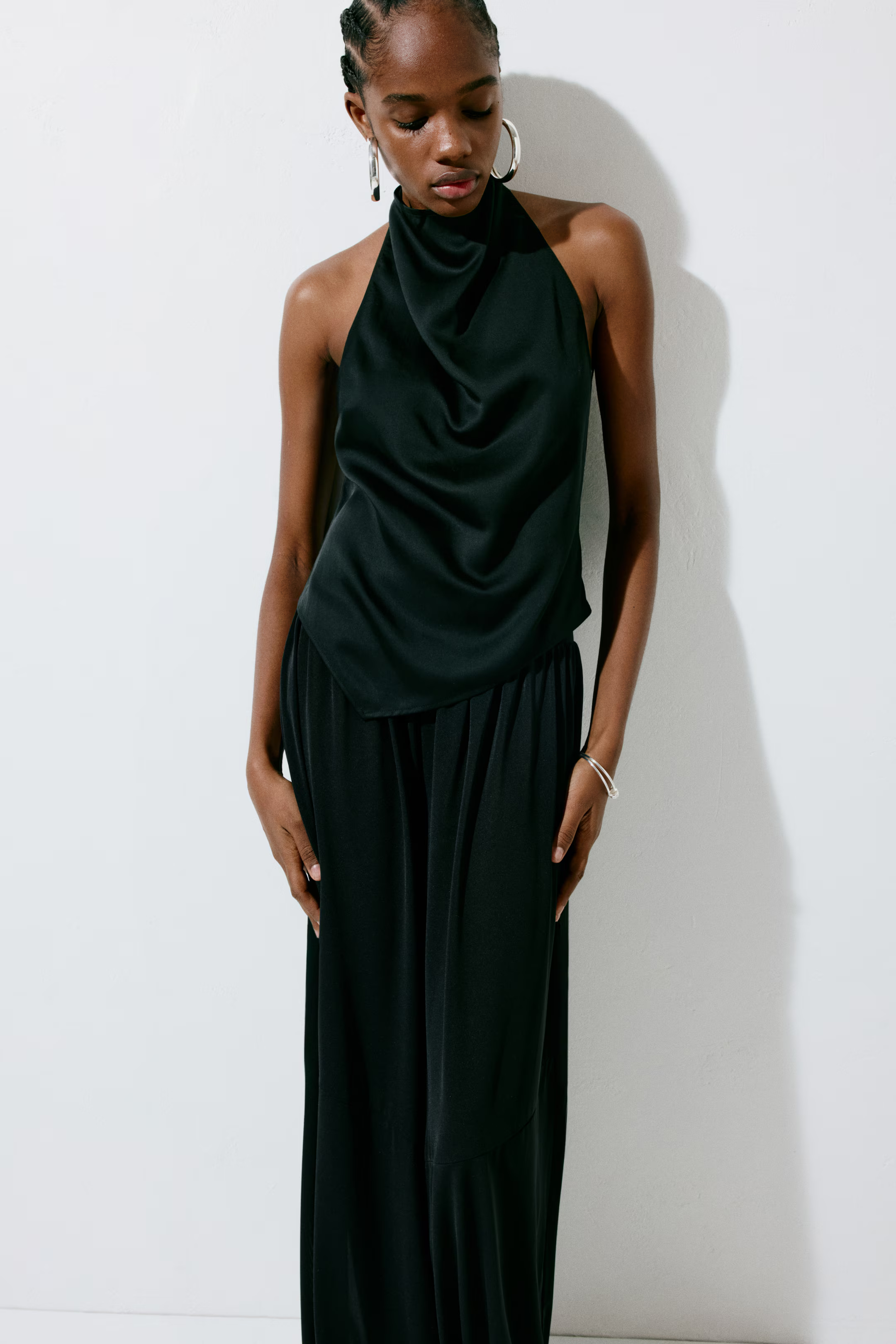 A model wearing a black H&M halterneck top.