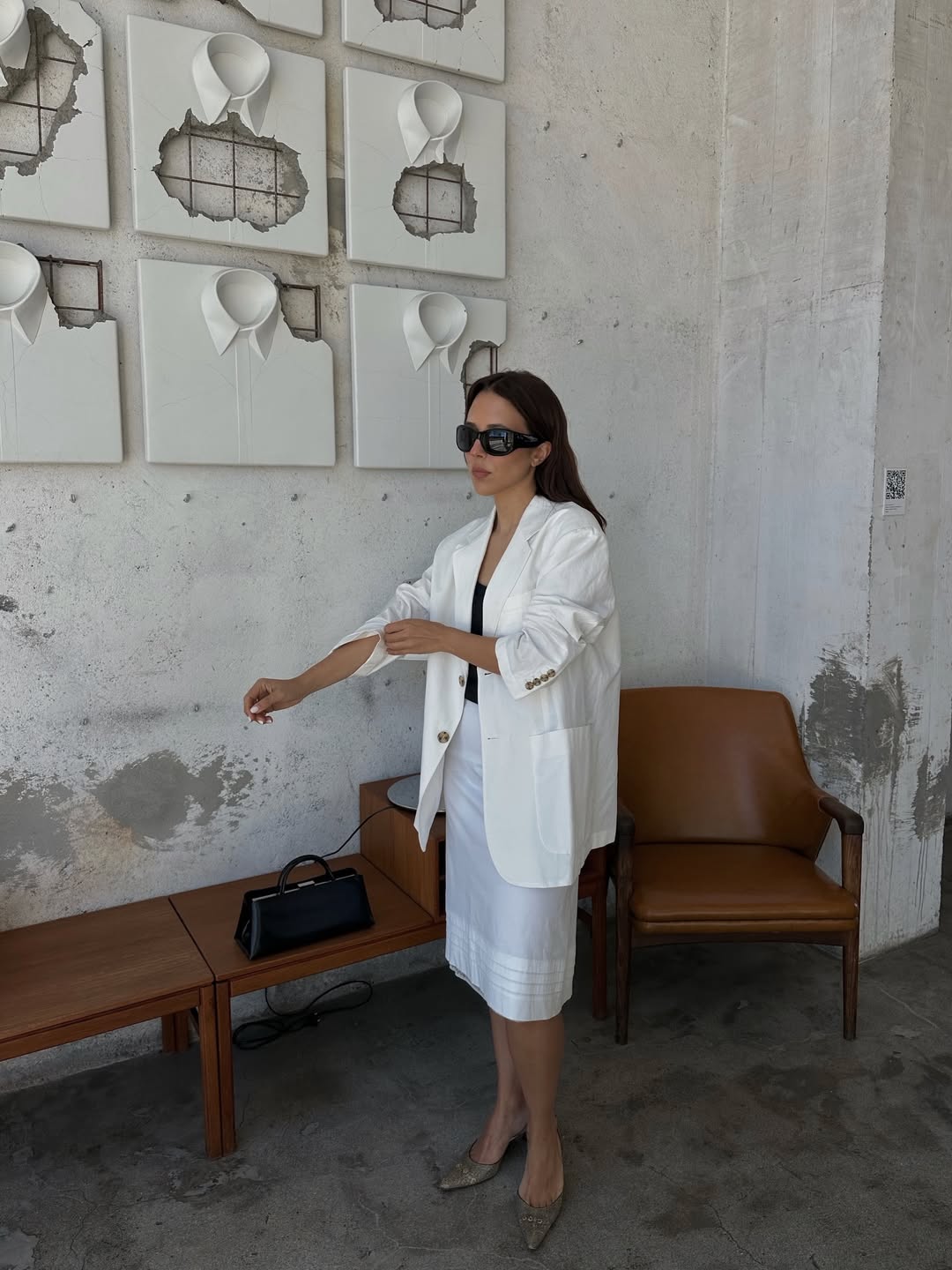 Debora in a white blazer and skirt
