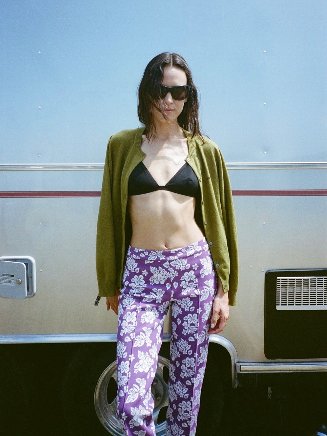 Alexa Chung wearing a green cardigan, a black bikini, and purple patterned pants.