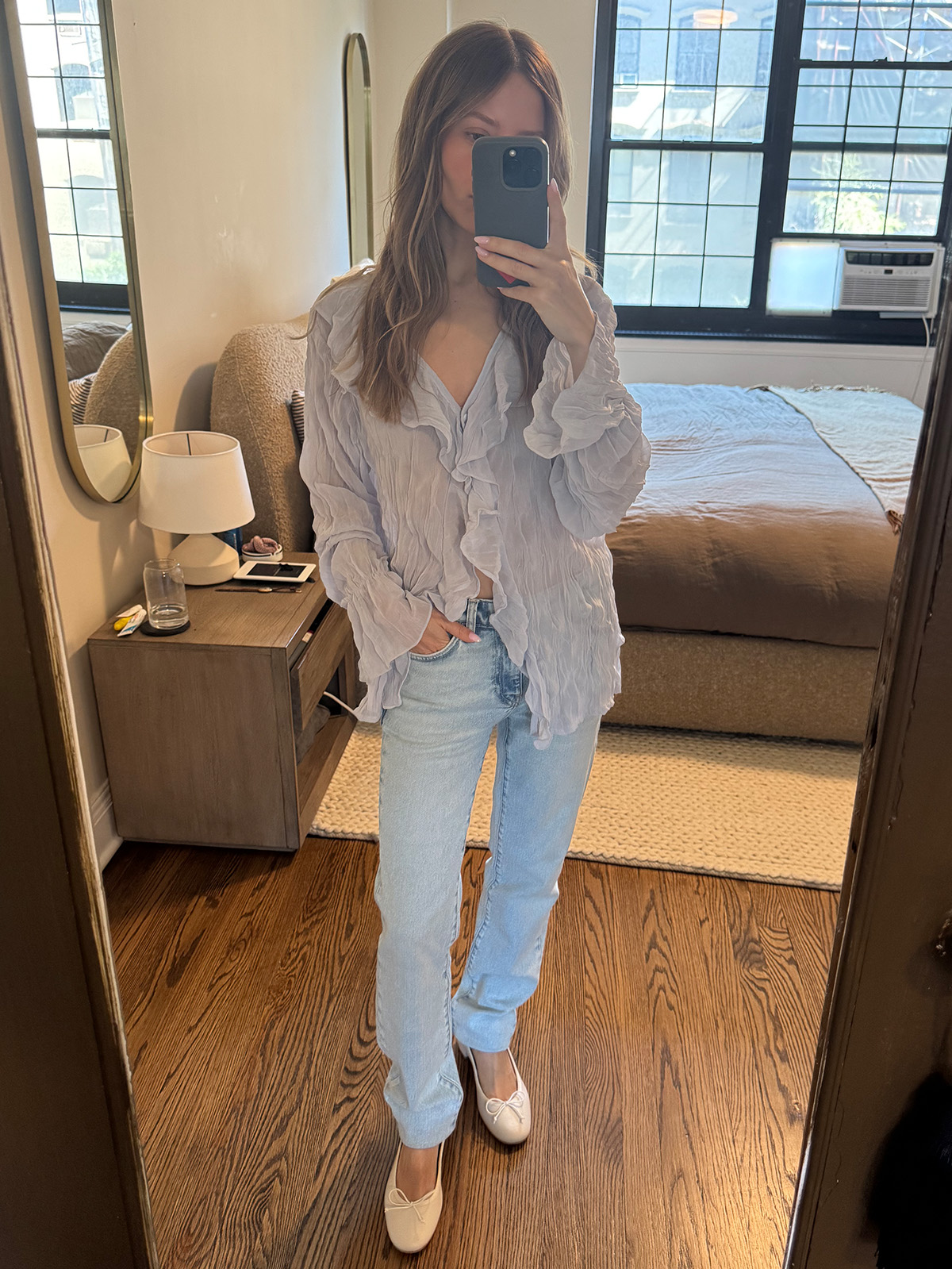 Nikki wears AG jeans with a blue blouse and white ballet flats.