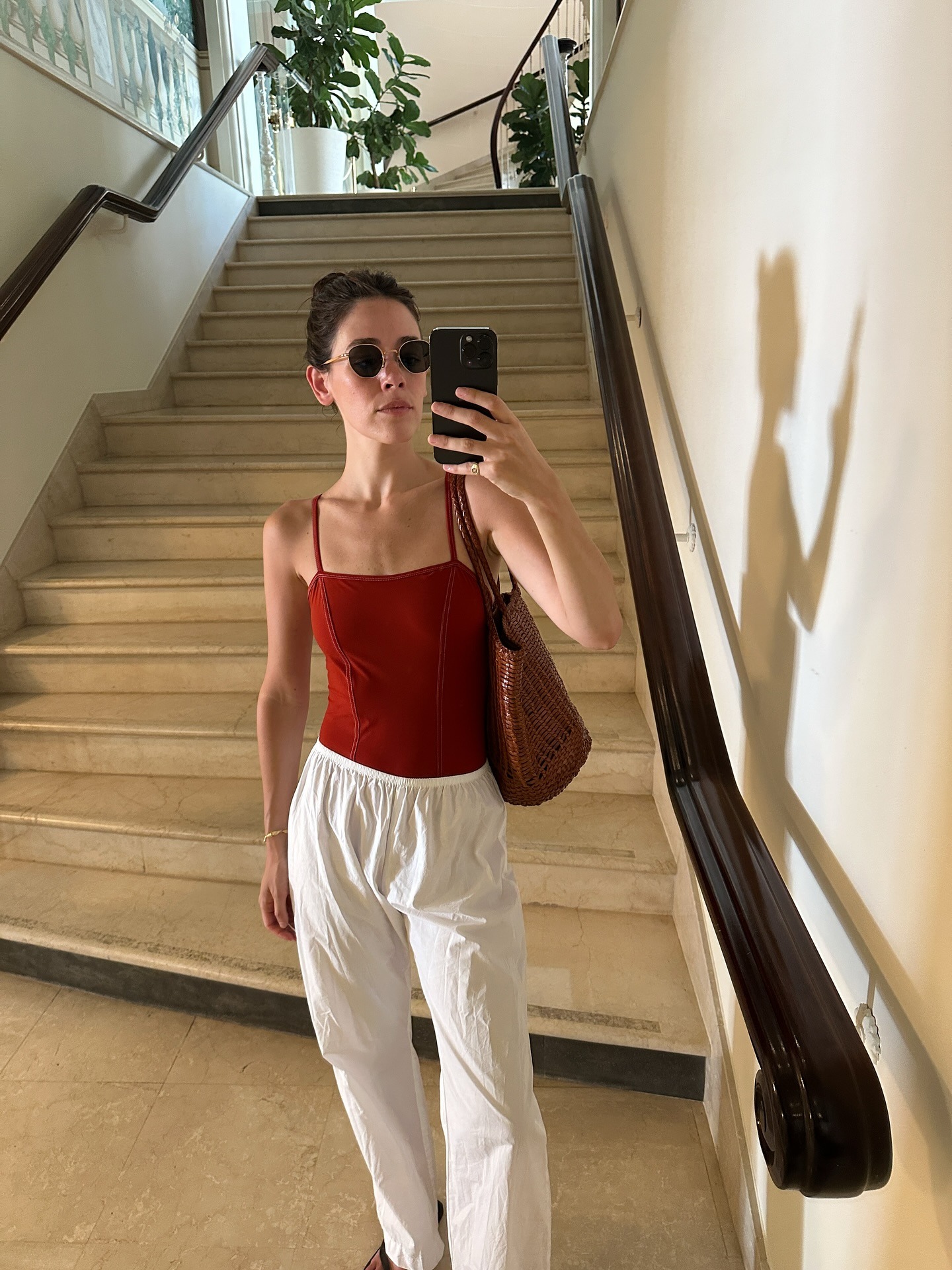 Ilana Torbiner wearing a red one-piece swimsuit with white beach pants.