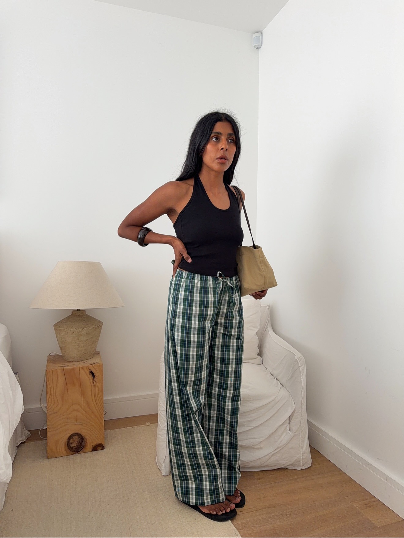 Influencer wearing a tank top, low-rise drawstring pants, and flip-flops