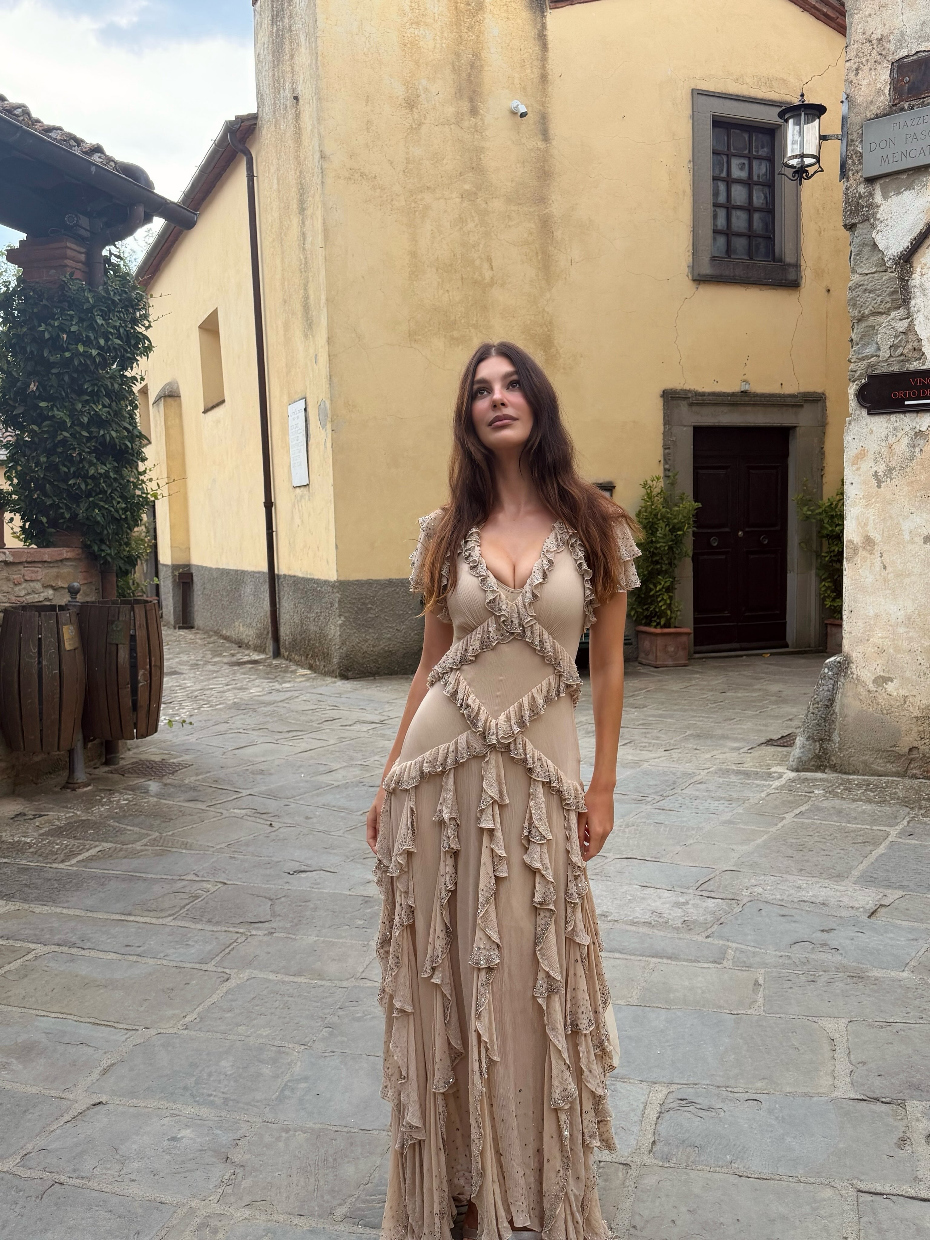 Camila Morrone wears a pink dress with ruffles to a wedding in Tuscany.