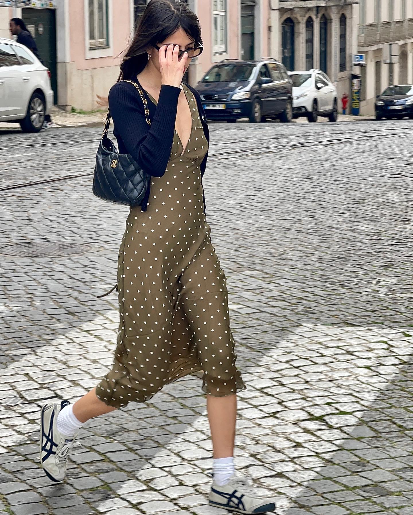 An image of @tamaramory wearing a polka-dot dress with slimline trainers.