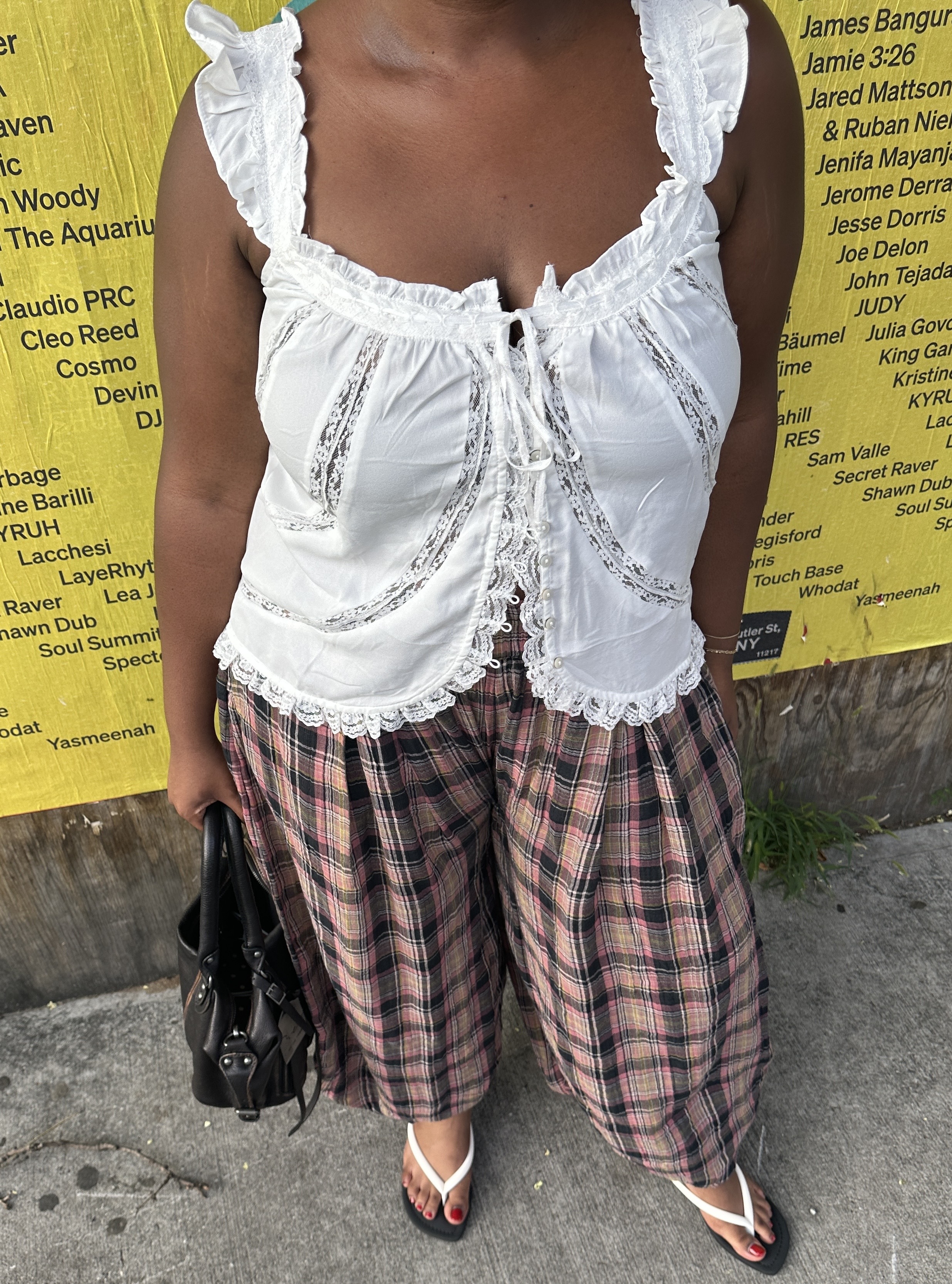 Editor wearing plaid pants and white top