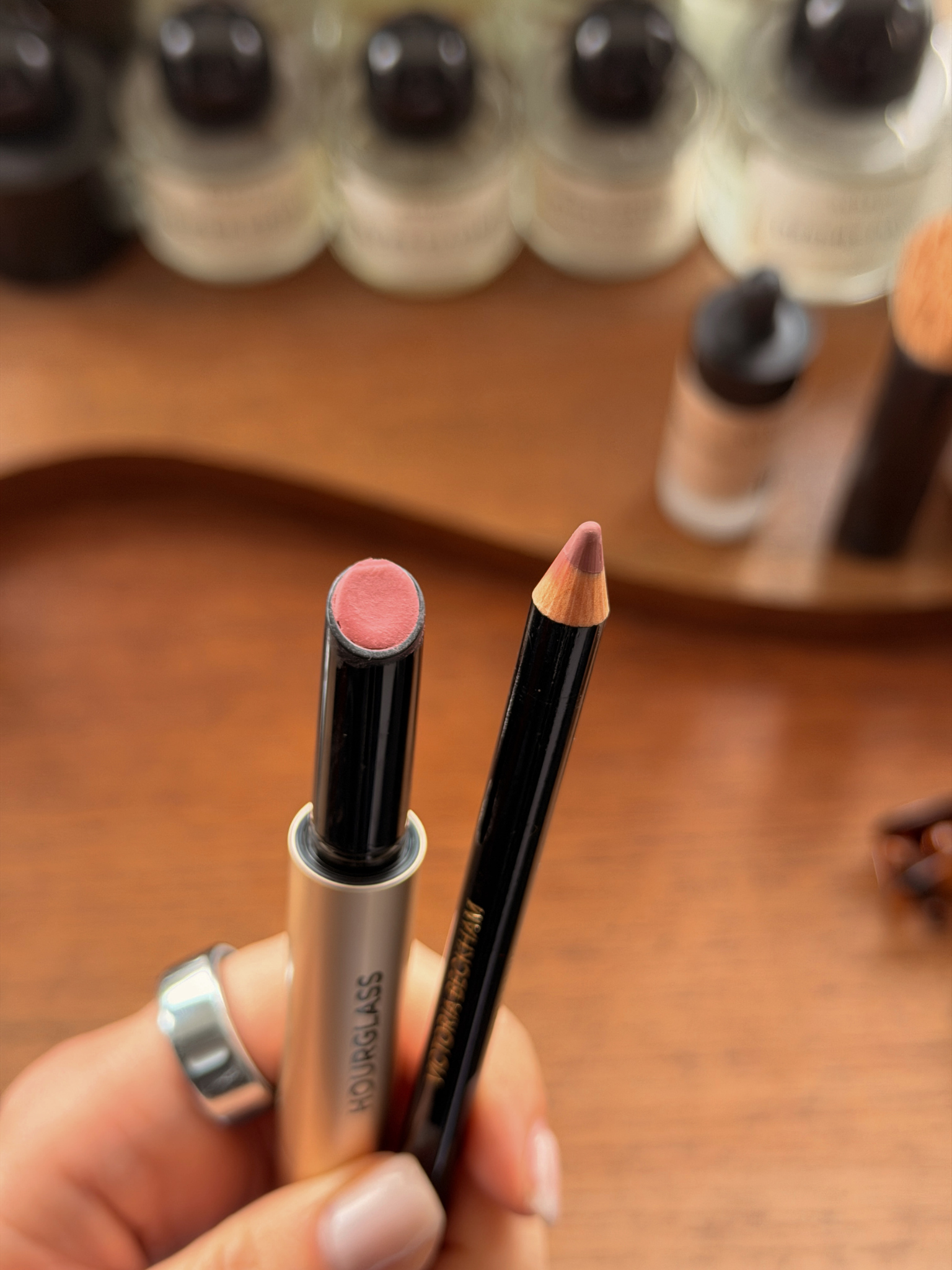 Grace Day holding Hourglass Phantom Blur Balm in Whisper and Victoria Beckham Beauty Lip Definer in 03