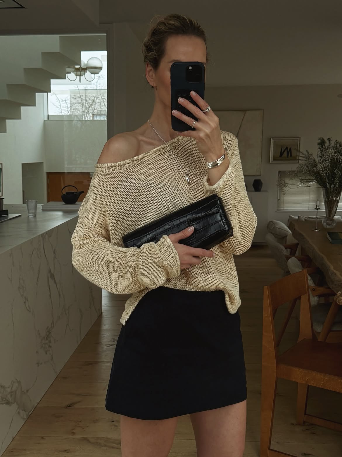 Anouk Yve wearing an open-knit summer sweater with a black mini skirt