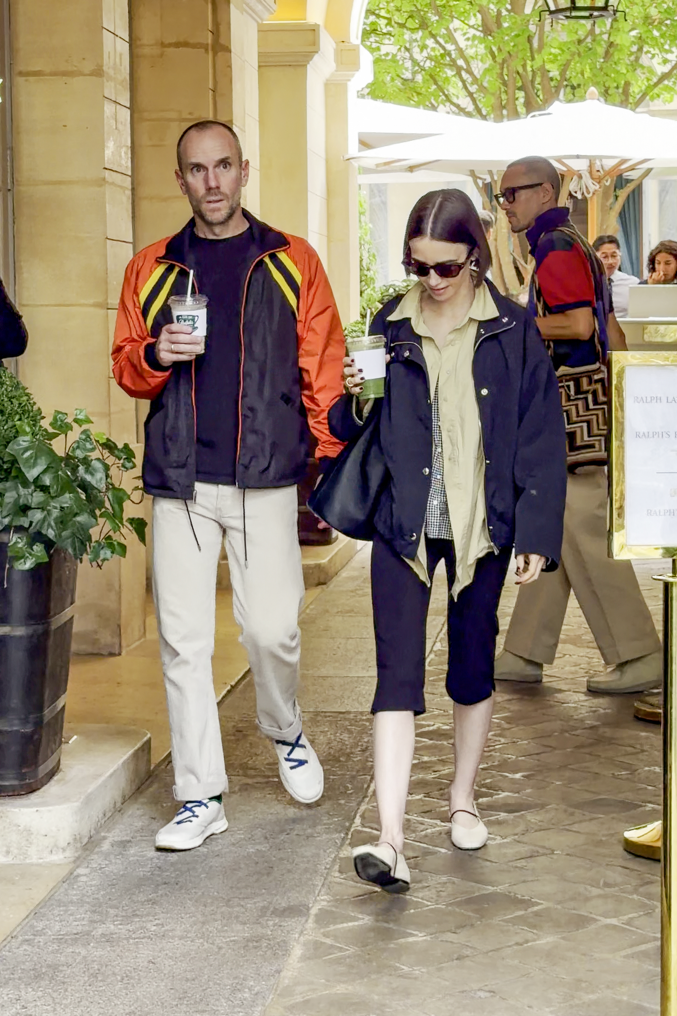 An image of Lily Collins wearing white ballet flats with capri leggings and a jacket.