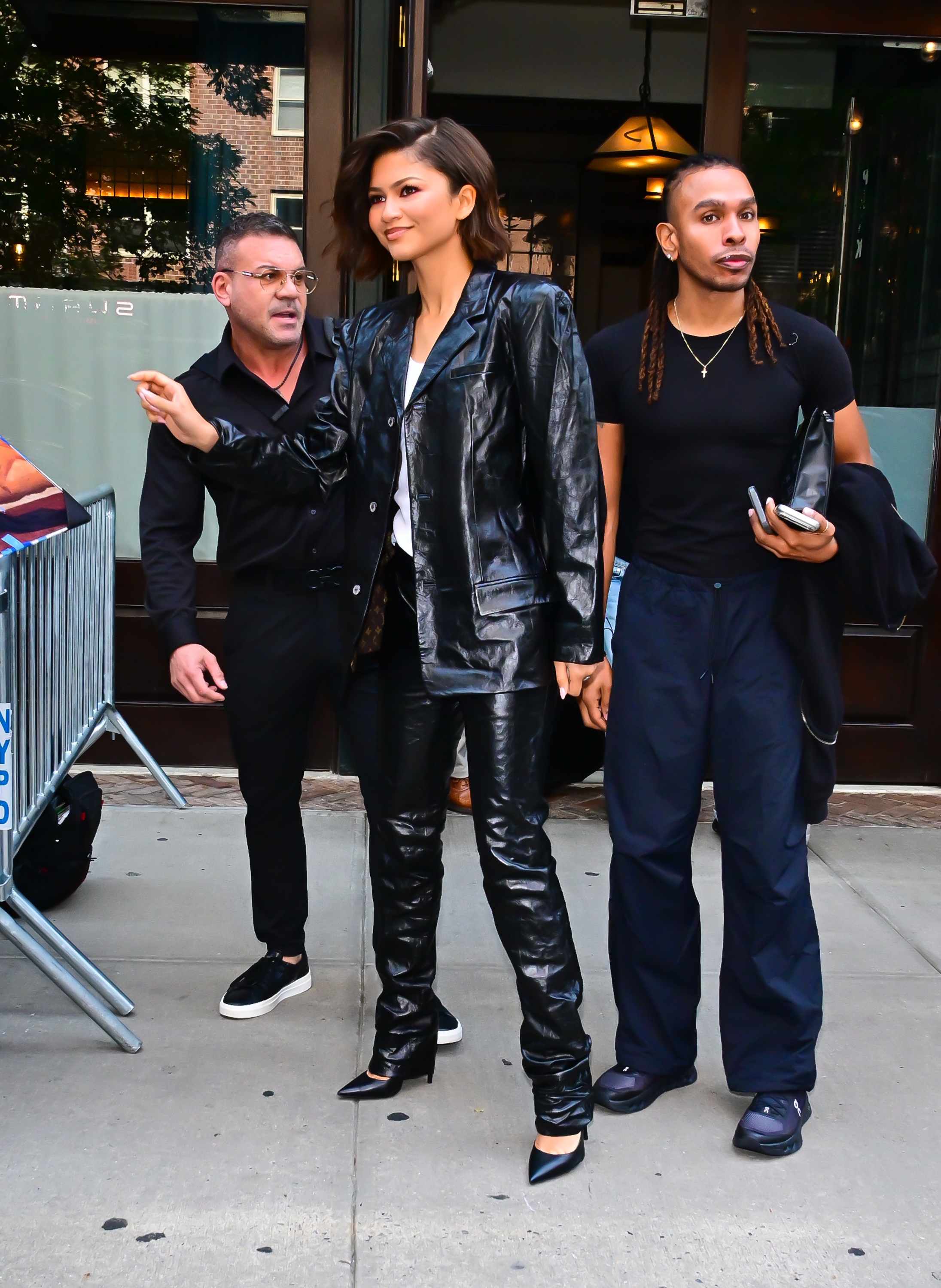 Zendaya wears a leather jacket, leather cigarette pants, and black pumps
