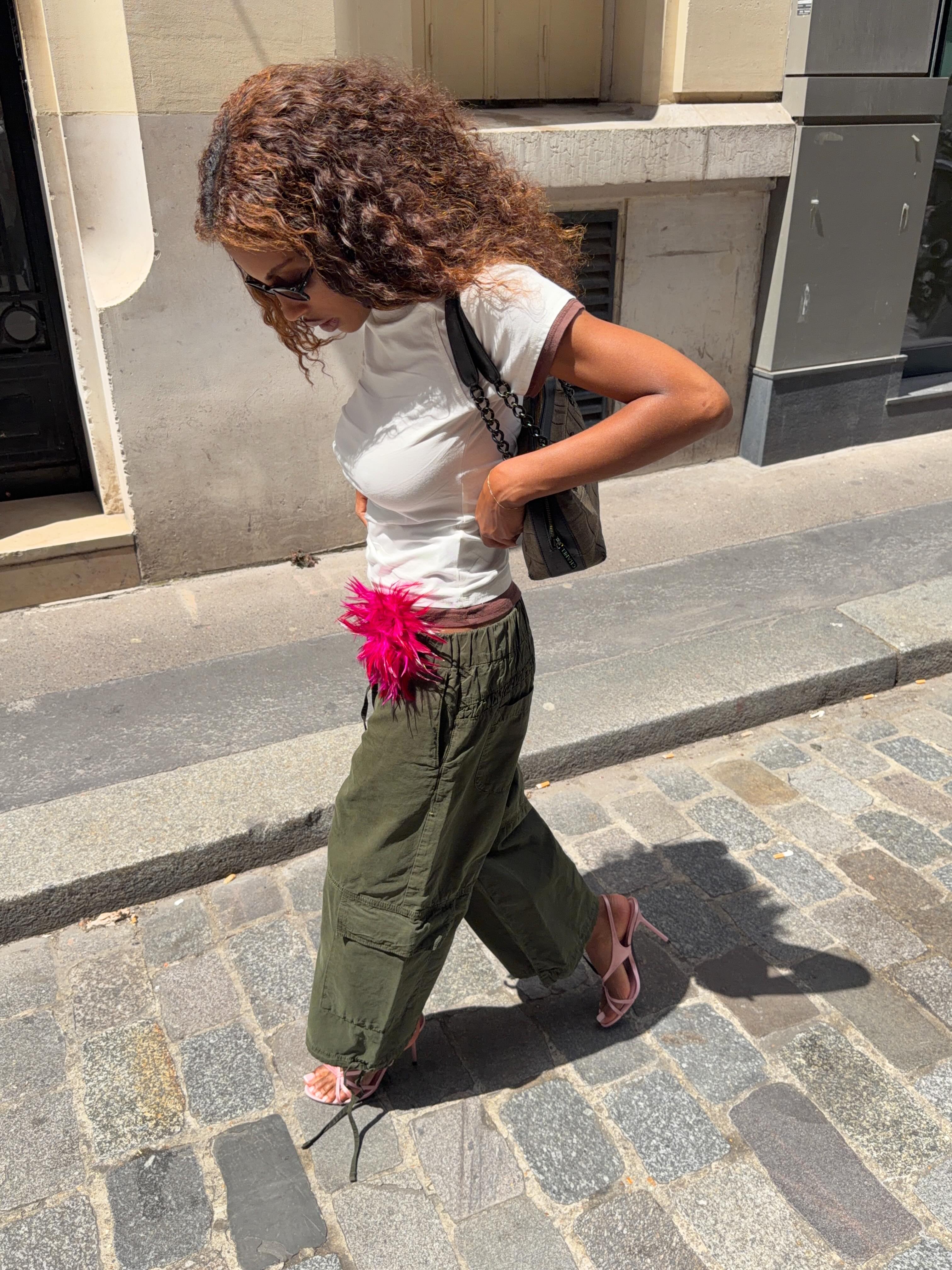 Marie-Victoire in khaki trousers and hot pink accessory