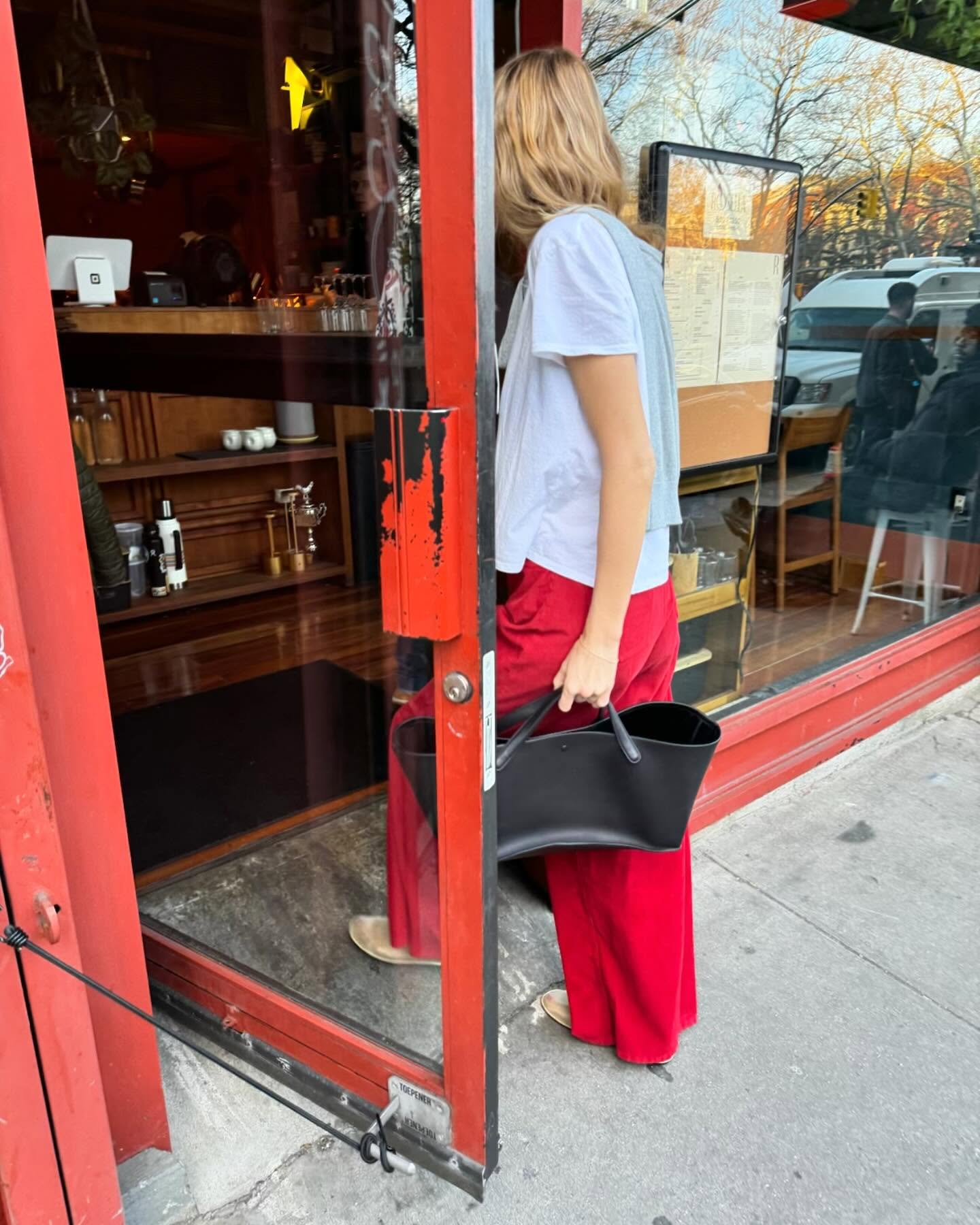 An image of @courtneygrow wearing butter yellow shoes with red jeans.