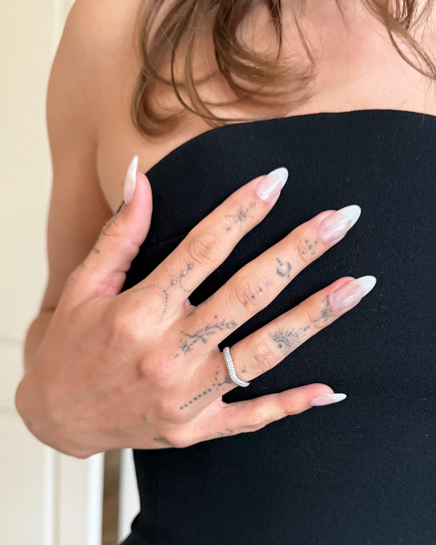 A close up of Hailey Bieber's sheer manicure