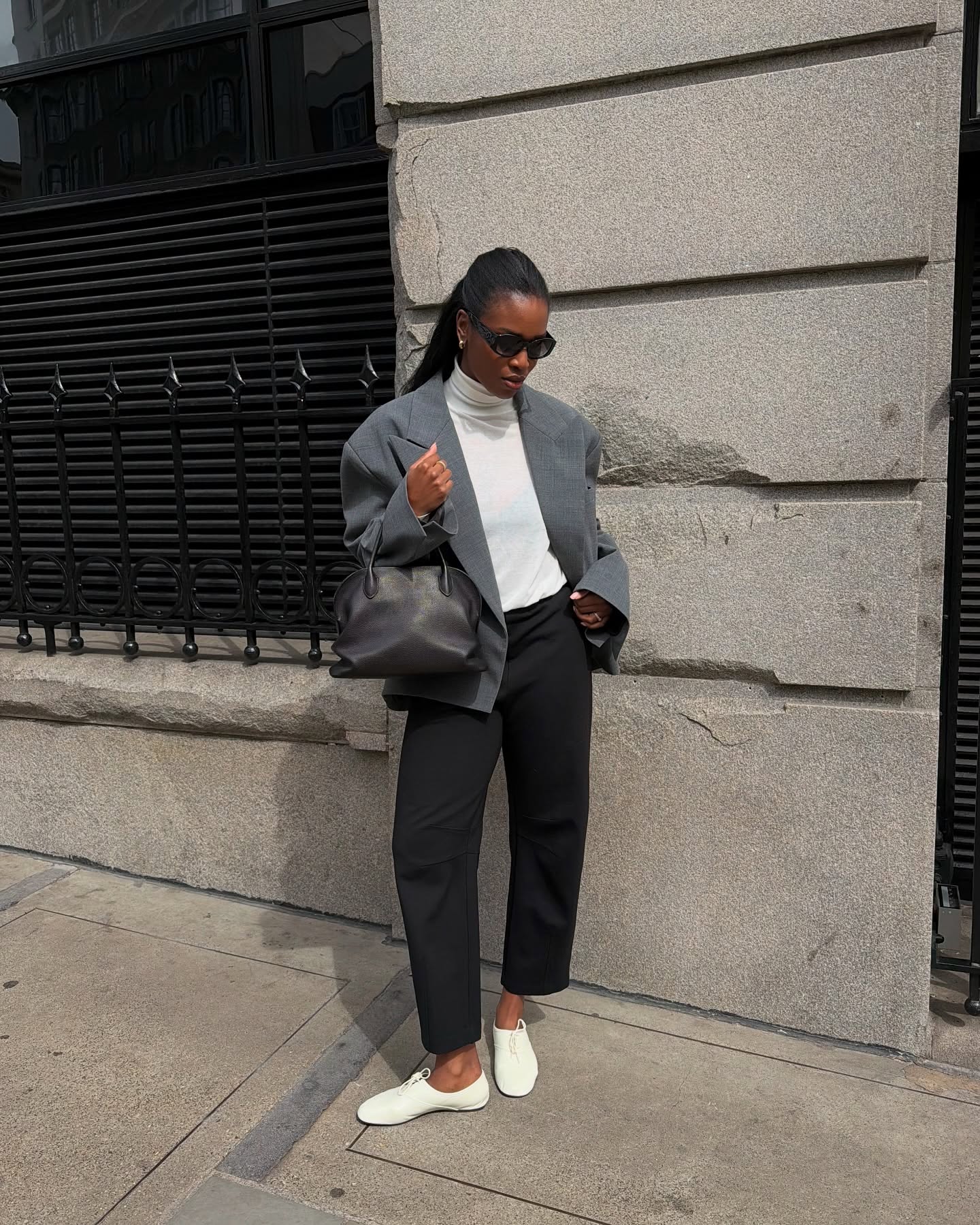 An image of @nlmarilyn wearing white derby shoes with cropped trousers, a bowling back, white roll neck and grey blazer.