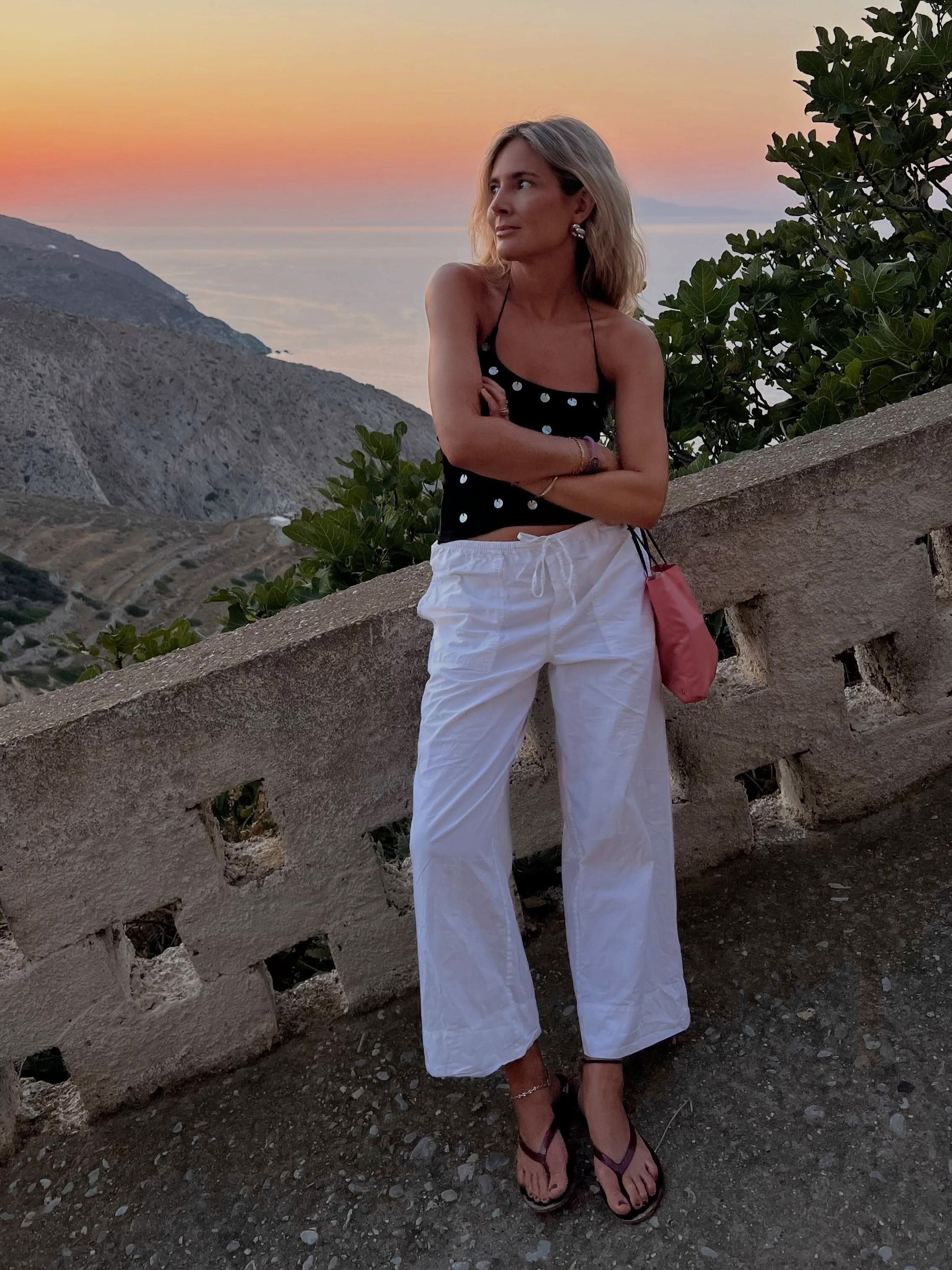Influencer wearing a tank top, low-rise drawstring pants, and flip-flops