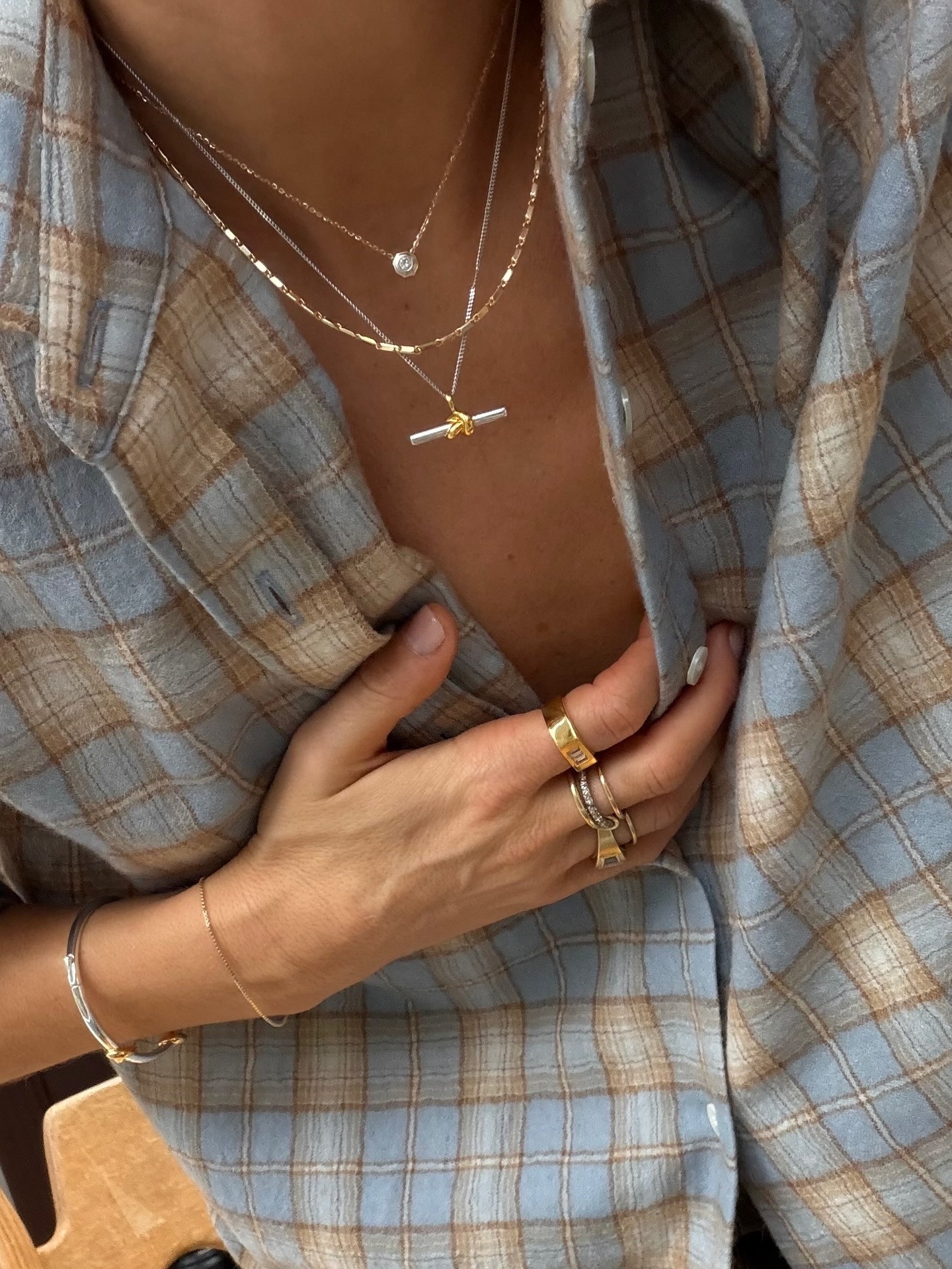 Influencer @lucywilliams02 stacks a t-bar necklace with other dainty necklaces.