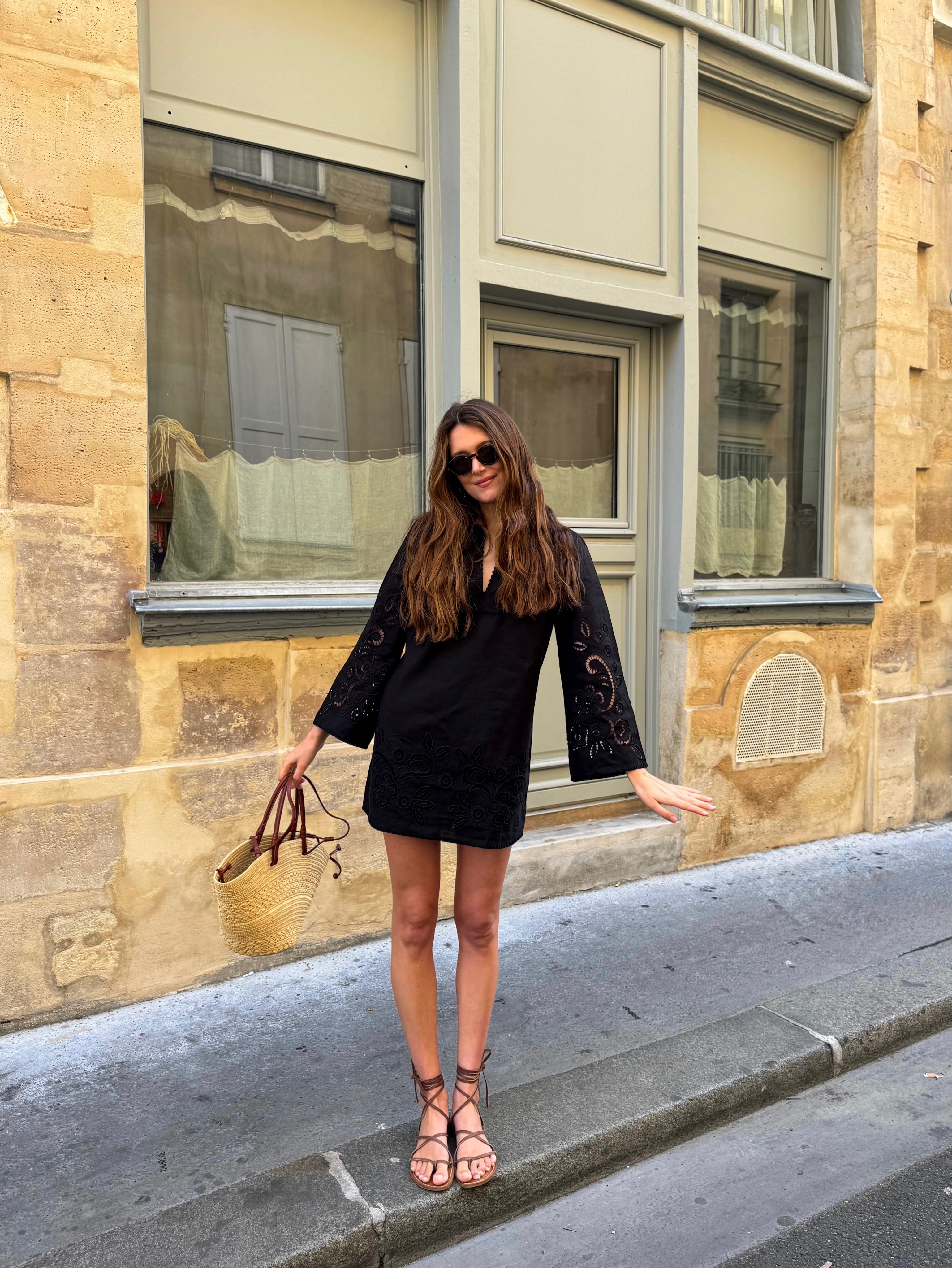 Sara in black mini dress and tie sandals