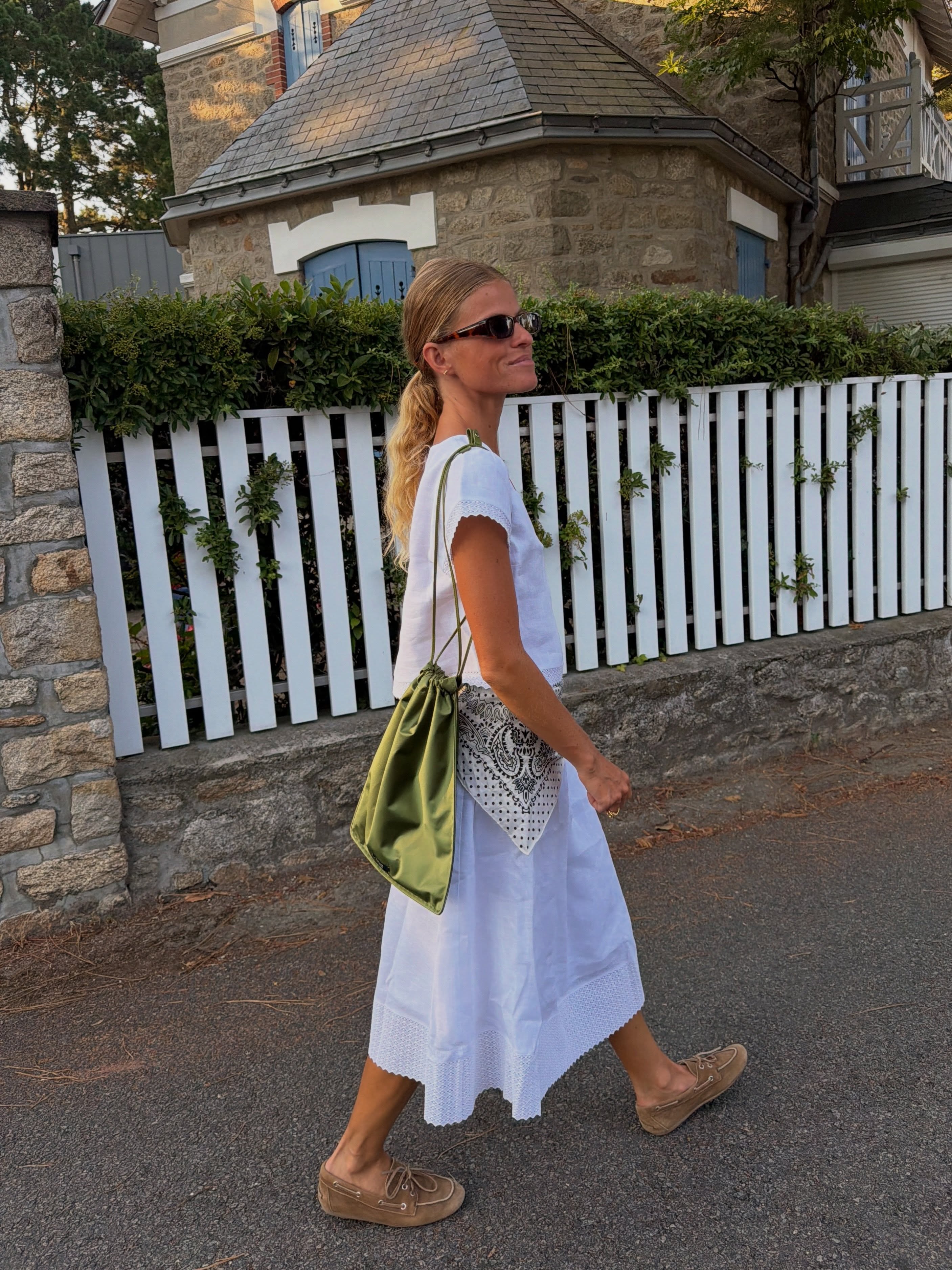 Influencer Alice Pilate wearing a green satin pouch bag.