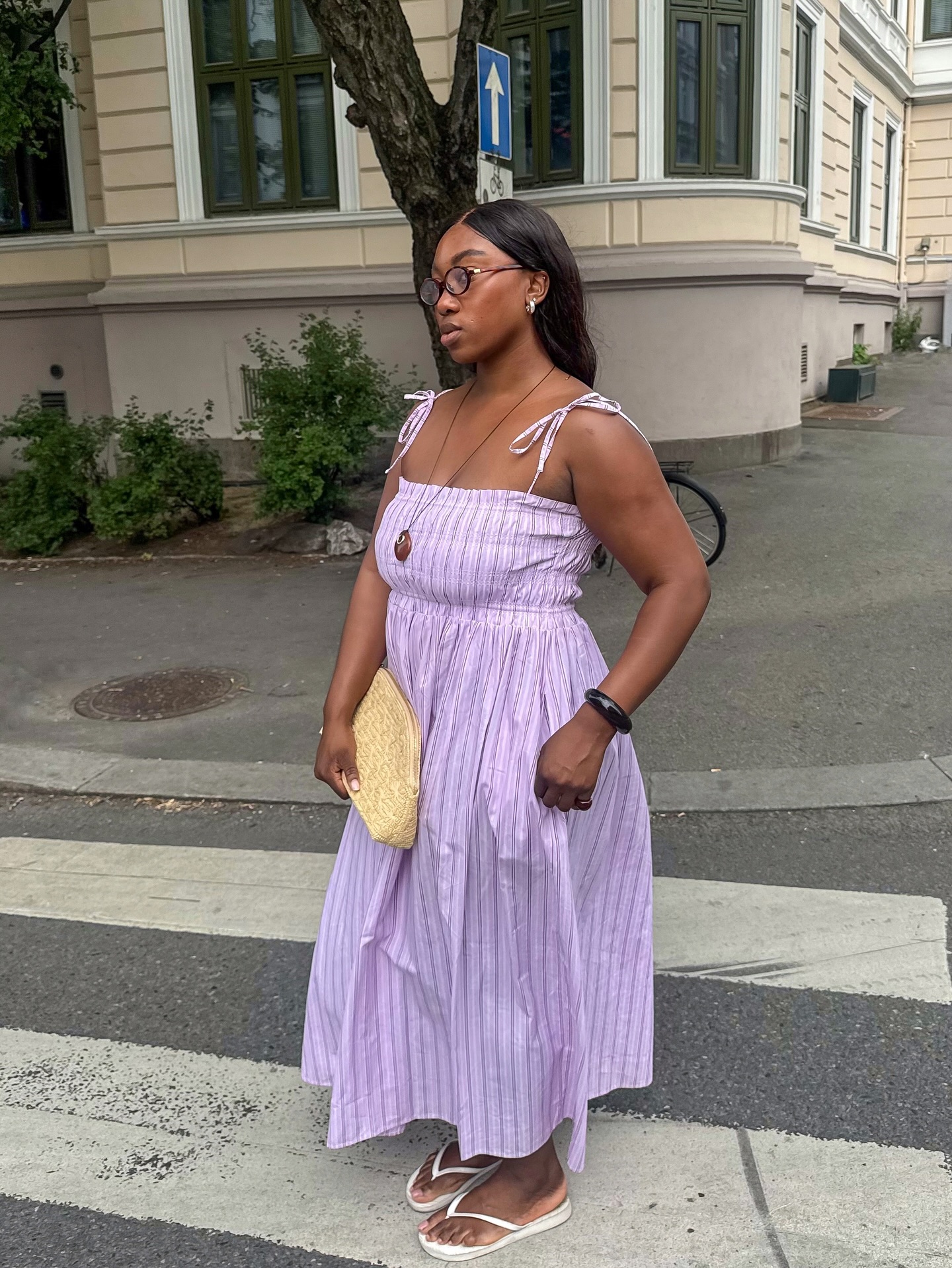 Nnenna in a purple maxi dress and white flip-flops