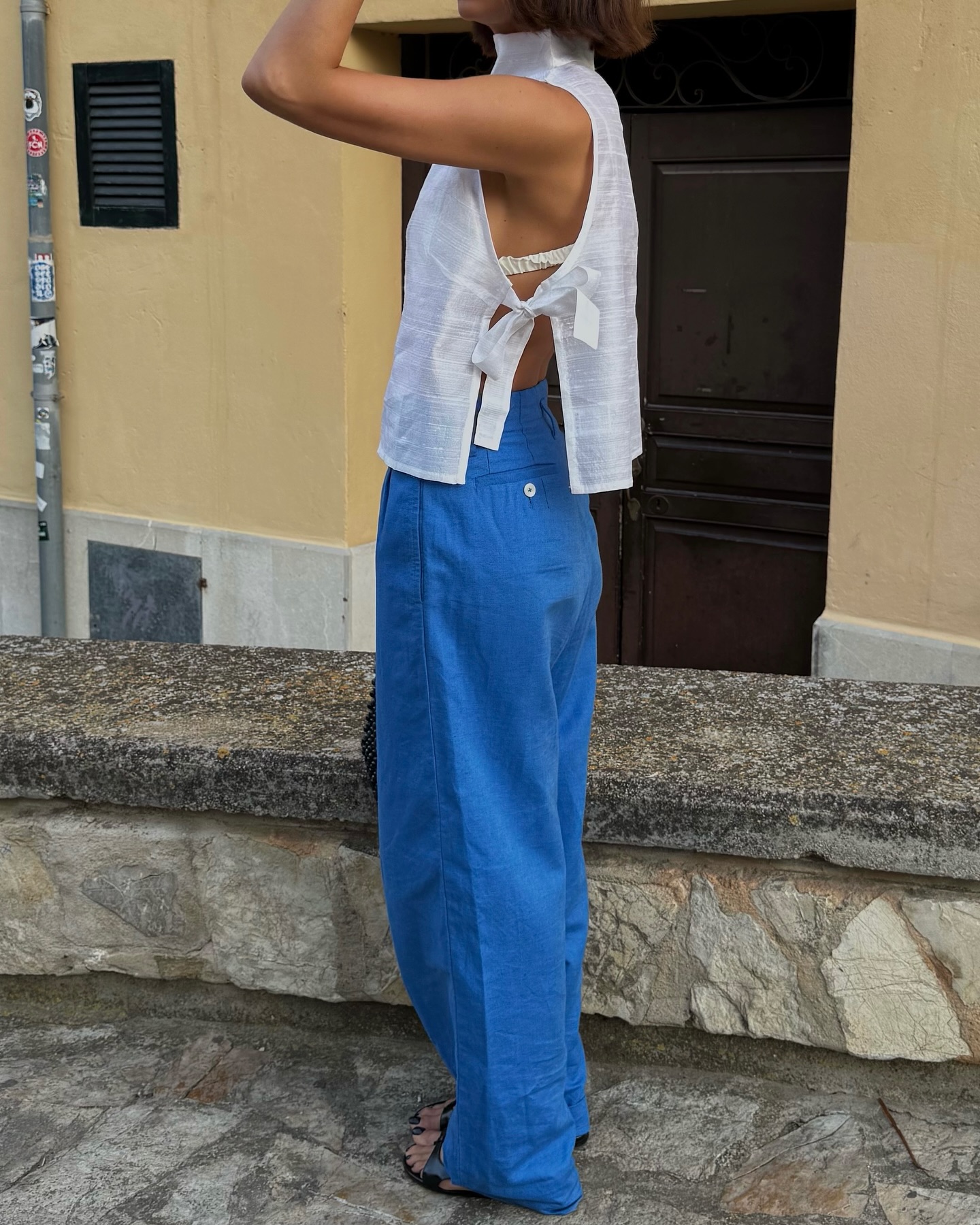 An image of @smythsisters  wearing a white apron top with cobalt trousers.