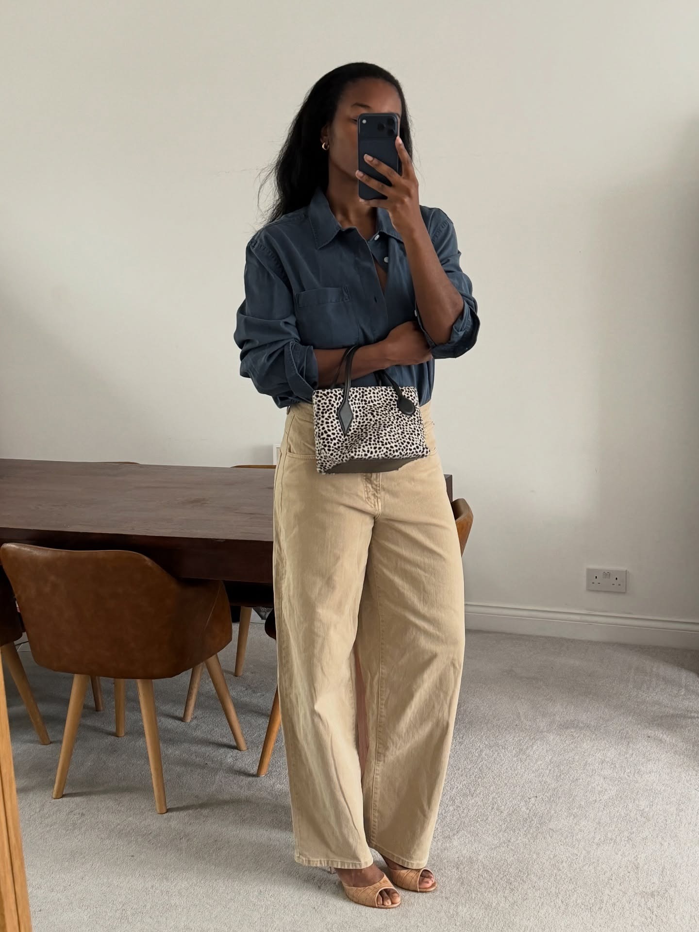 Influencer wearing dark beige pants with a button-down shirt and high-heel mule sandals