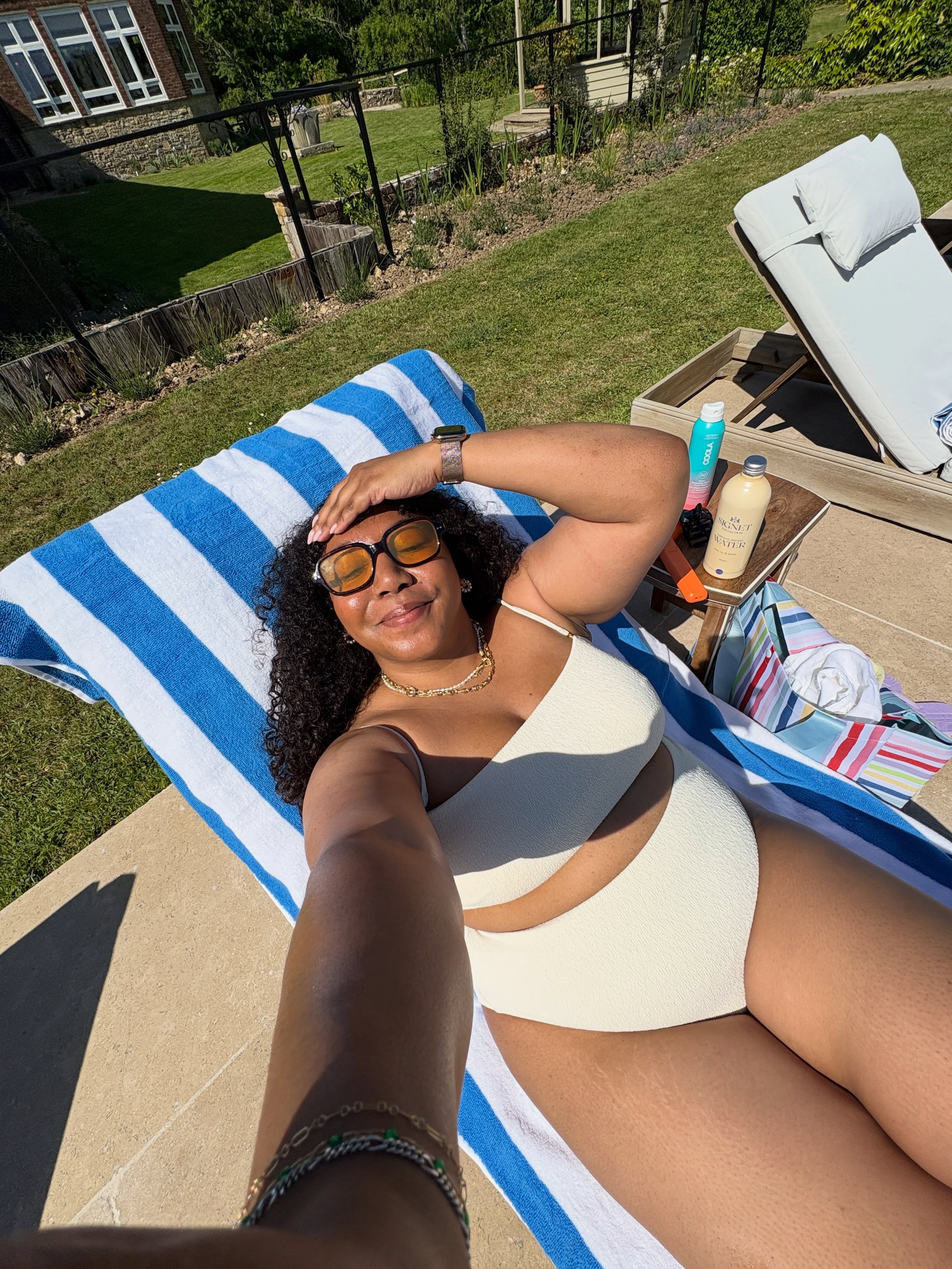 nicole ocran wears a cream bikini on a sun lounger