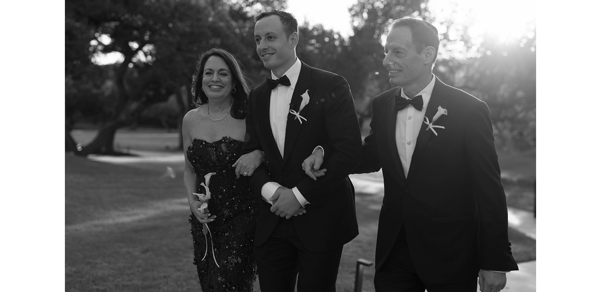 Image of Adam and his parents at their wedding ceremony.