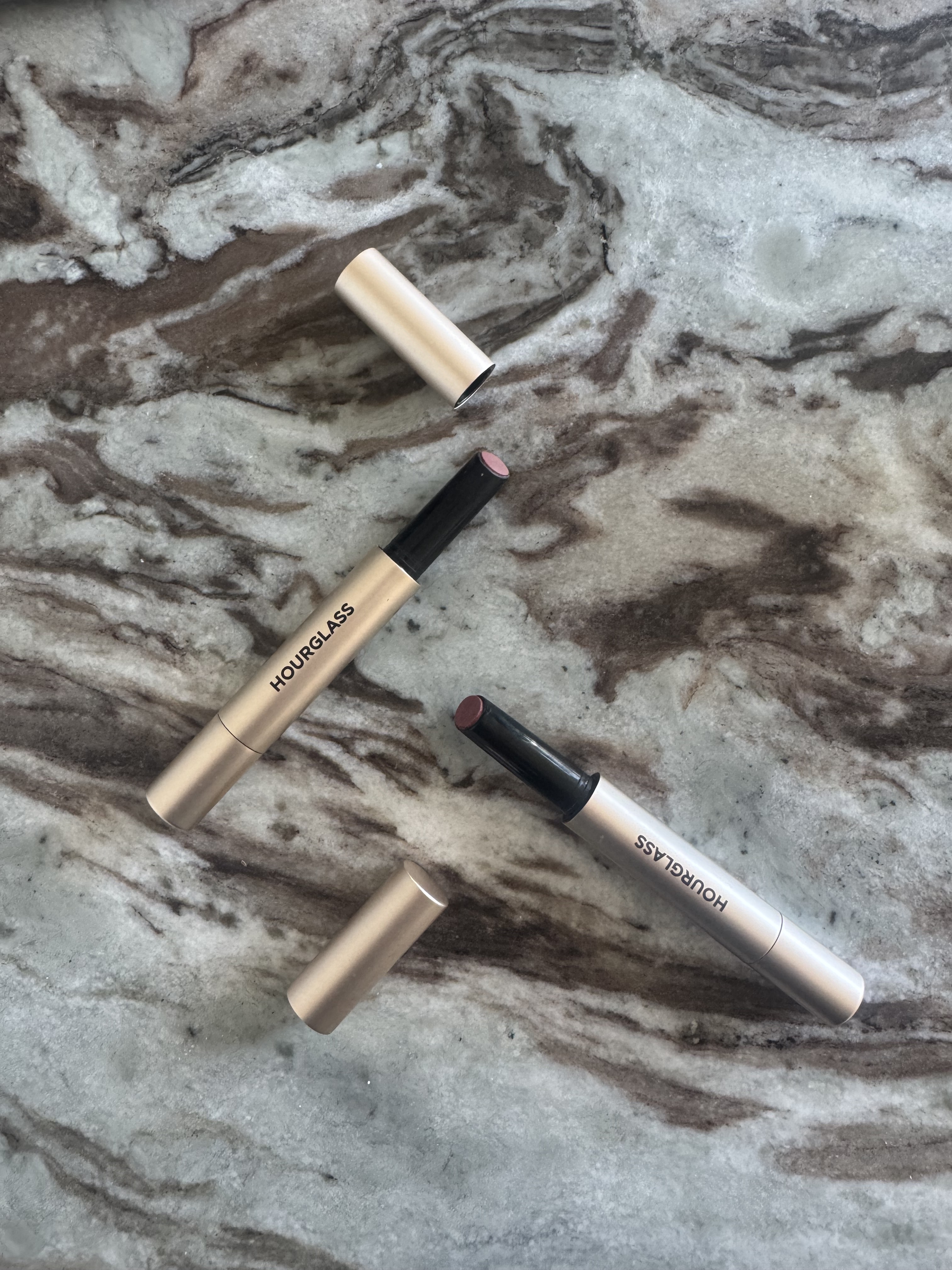 The Hourglass Phantom Blur Balms on a marble table