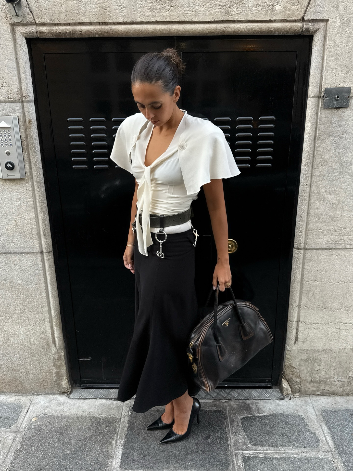 @hannamw wearing a Prada blouse with a black midi skirt and pumps.