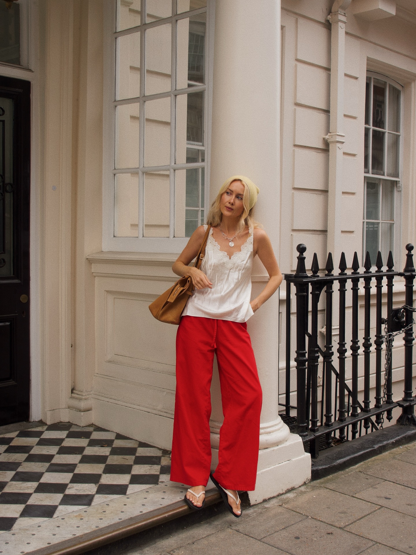 An image of @chloekathbutler wearing red trousers with a white apron top and white flip-flops.
