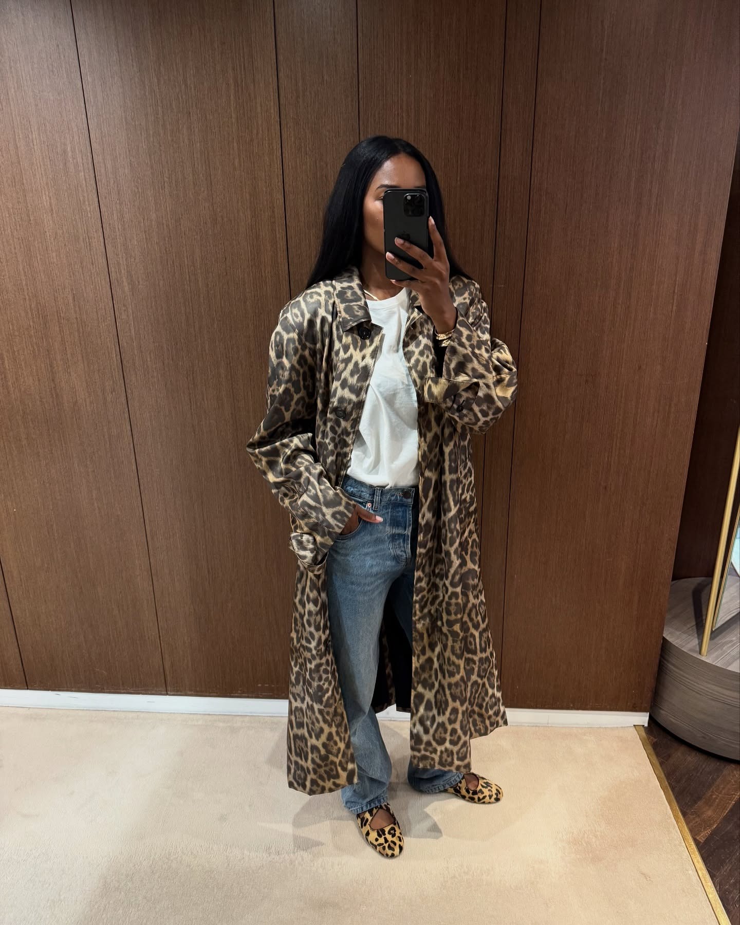 @nlmarilyn wearing baggy jeans, animal-print flats, a white tee shirt, and animal-print trench