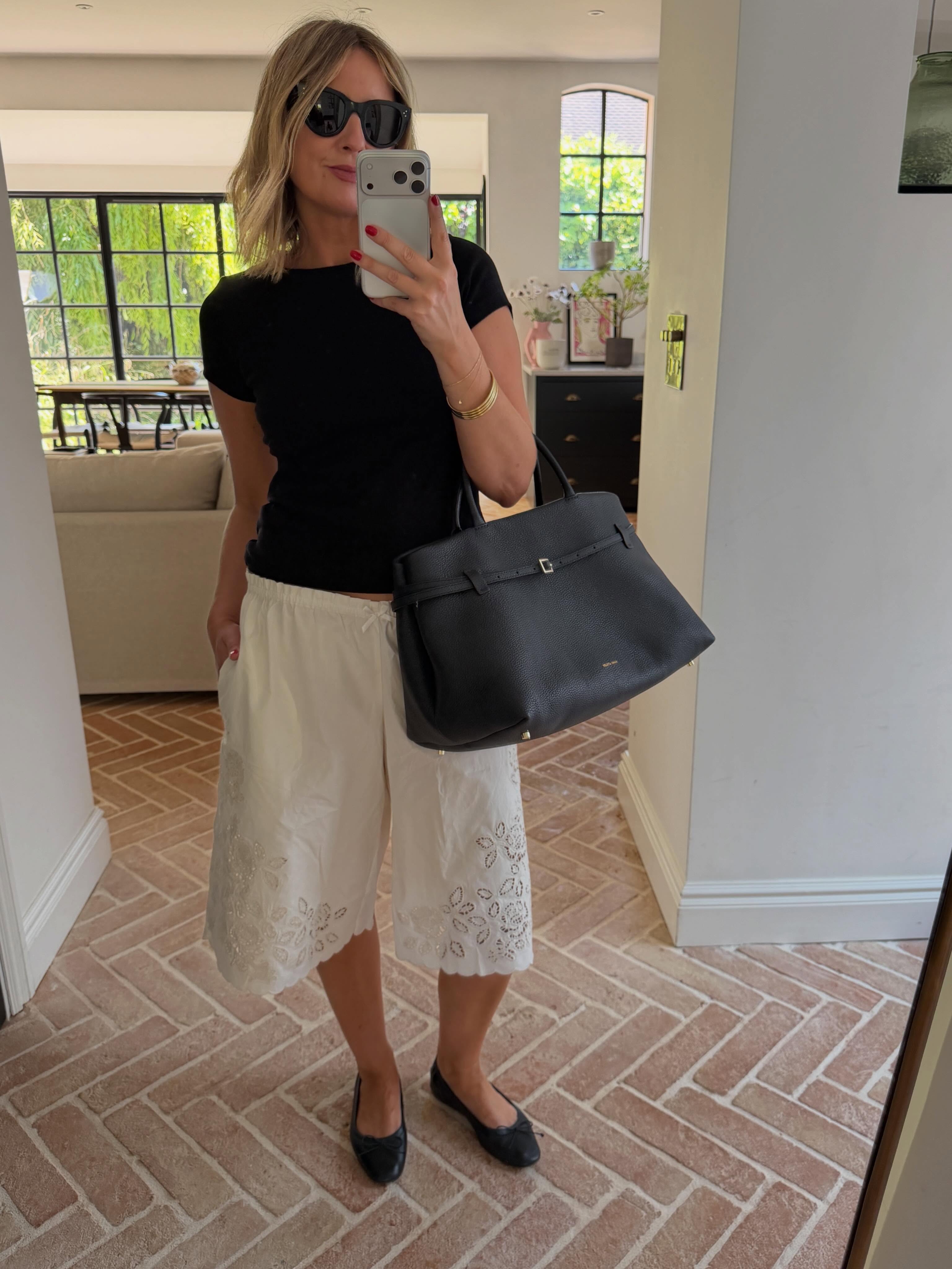 Influencer Emma Rose Thatcher wearing white cotton Bermuda shorts.