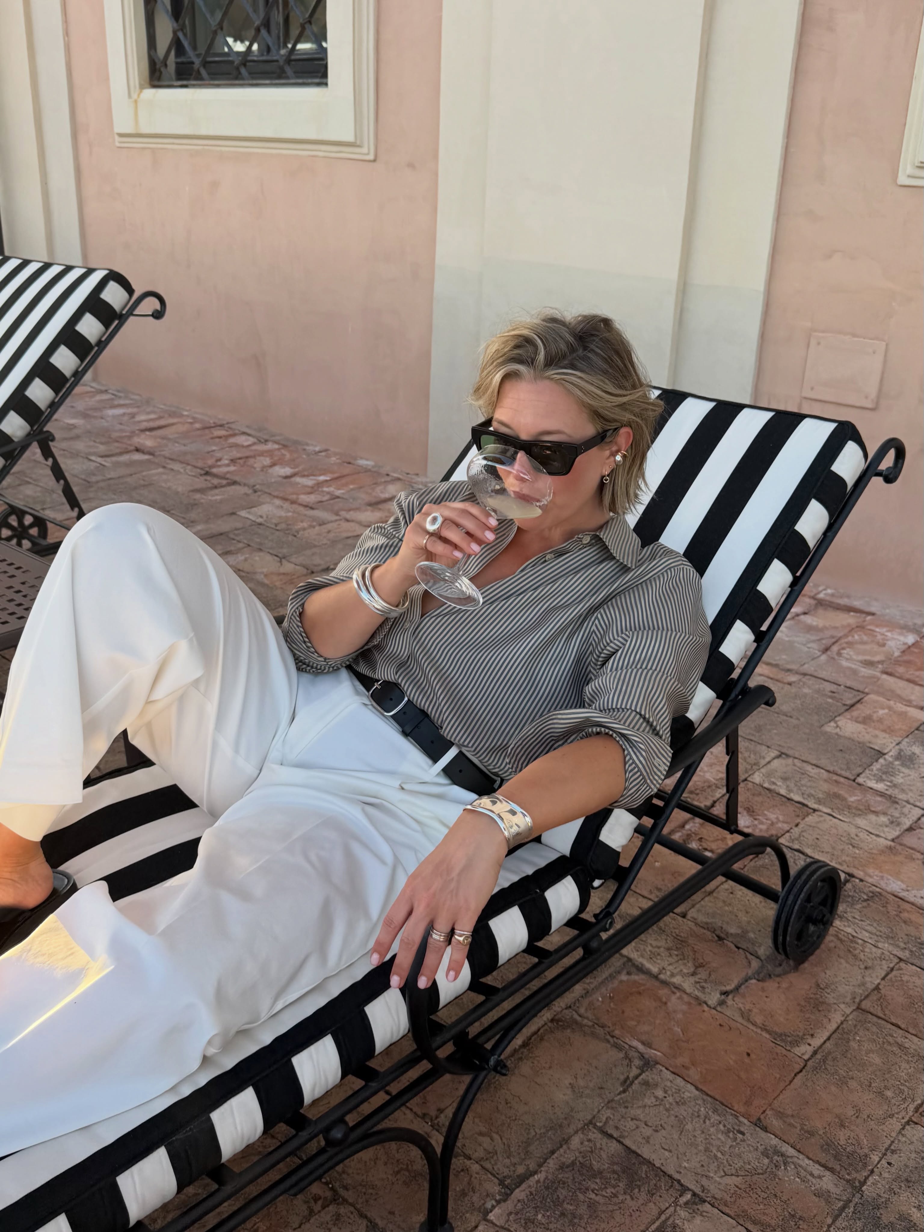 Alexis in a striped top and white trousers