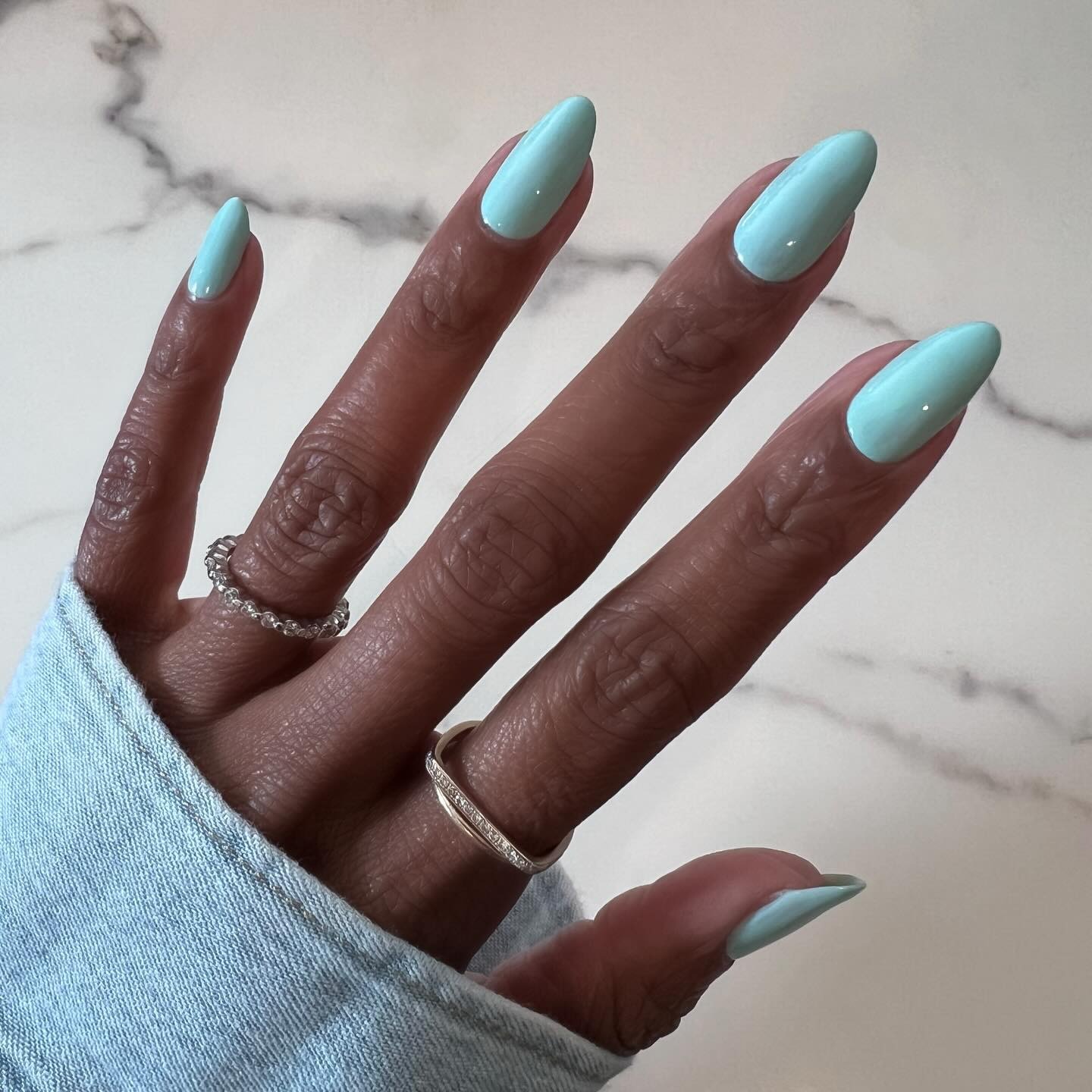 A close-up of a turquoise manicure