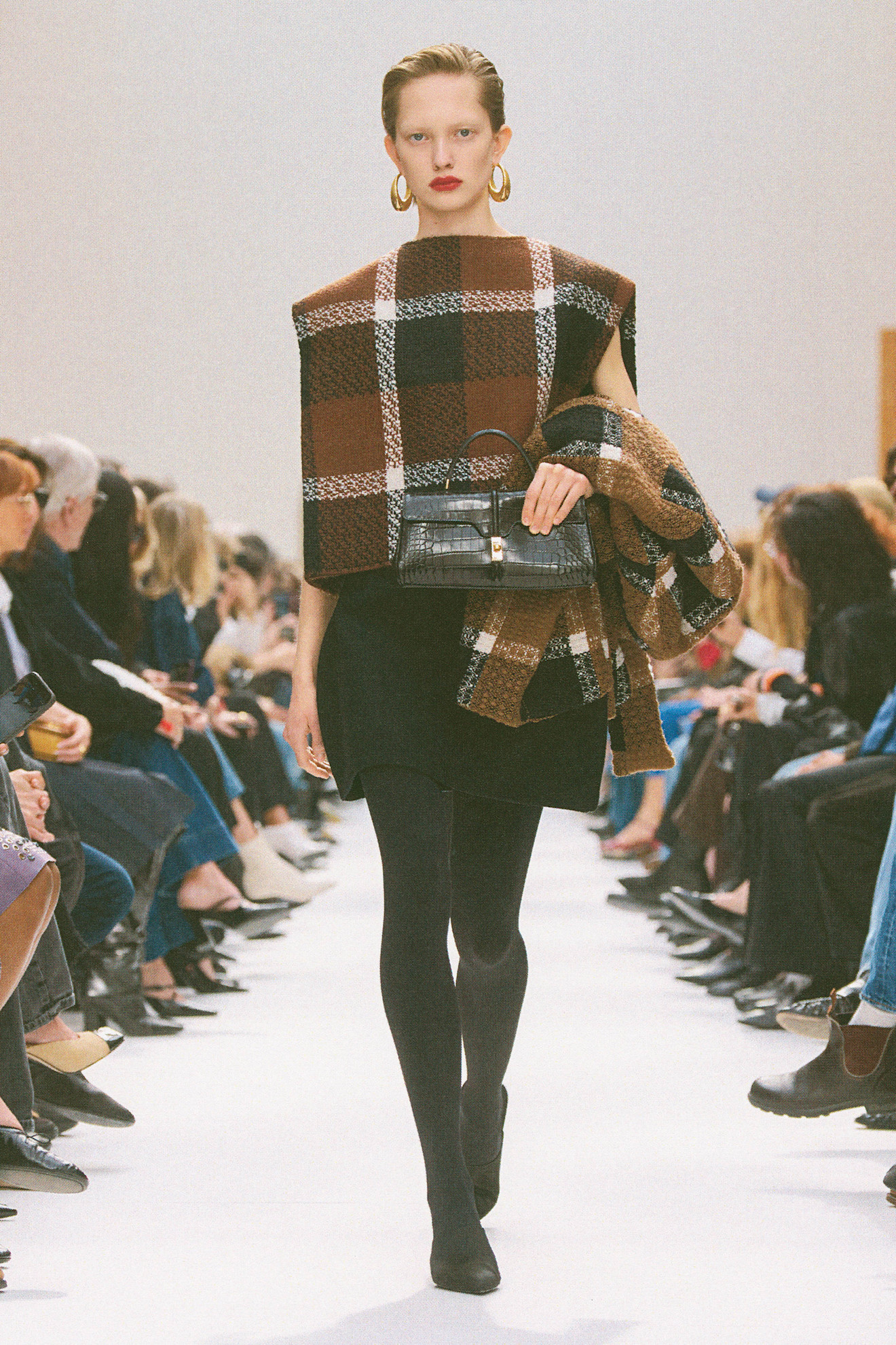 Woman in a plaid top on the Celine runway.