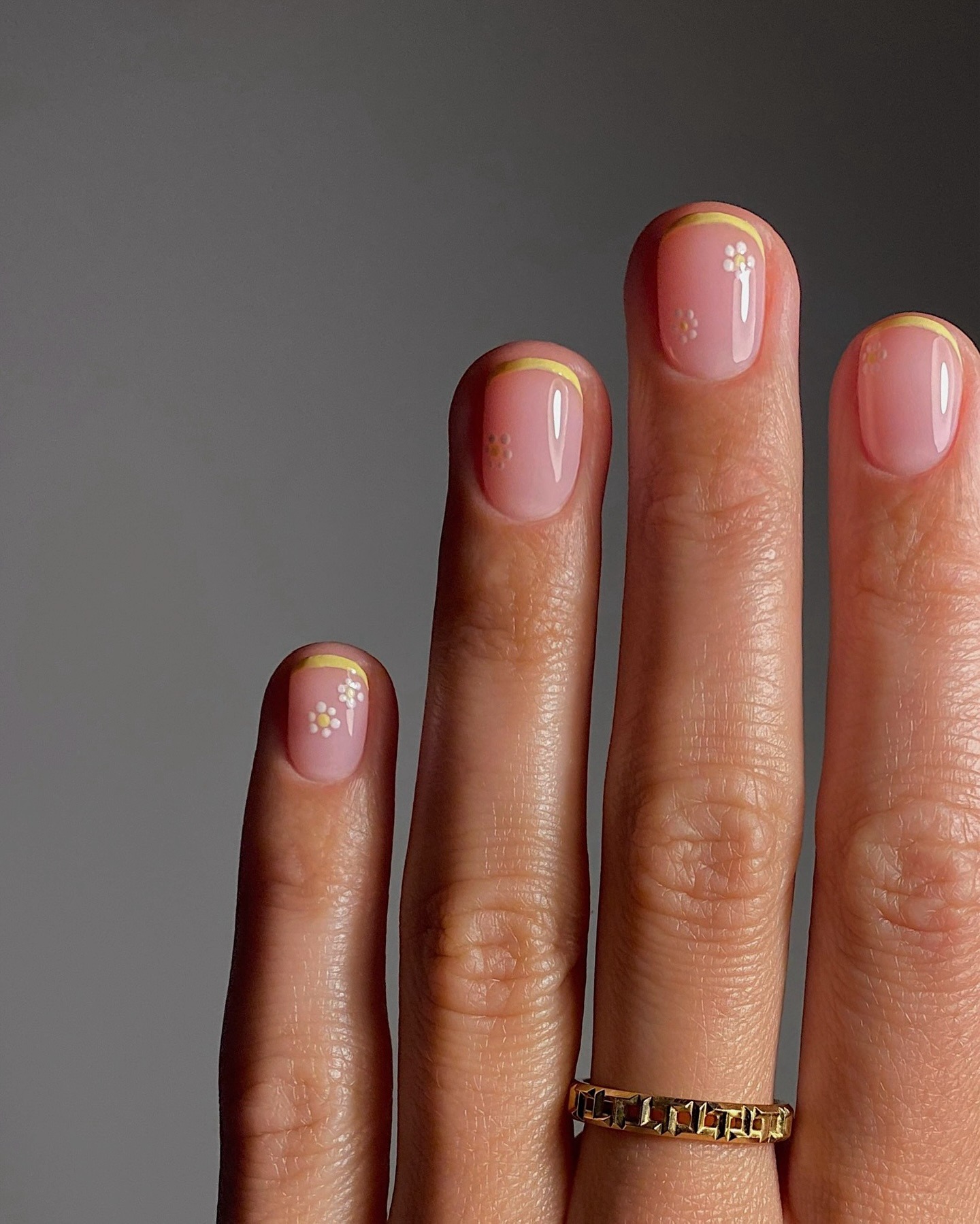 A butter yellow French tip manicure with daisy nail art