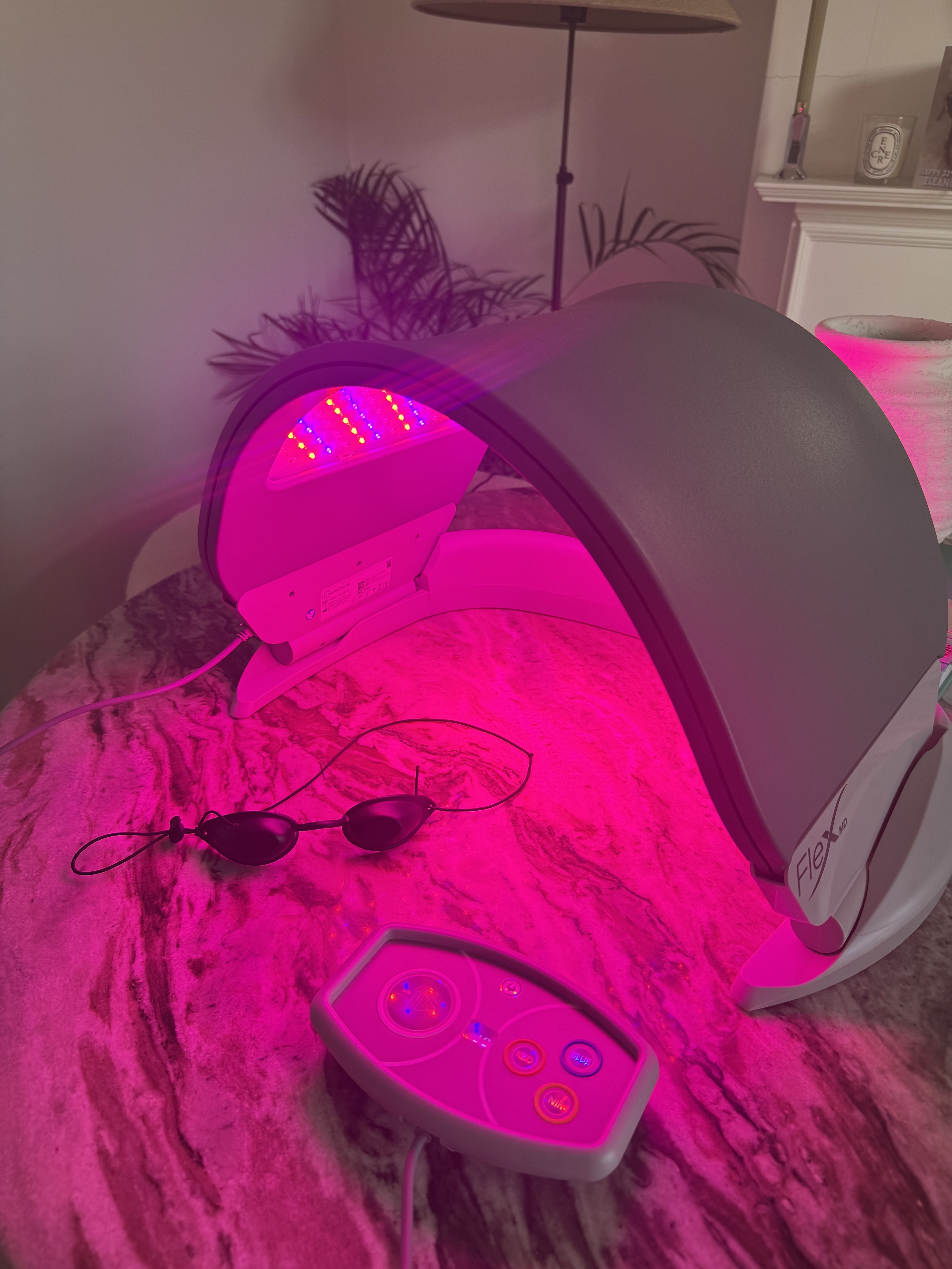 The Dermalux MD LED panel switched on, with the remote and goggles