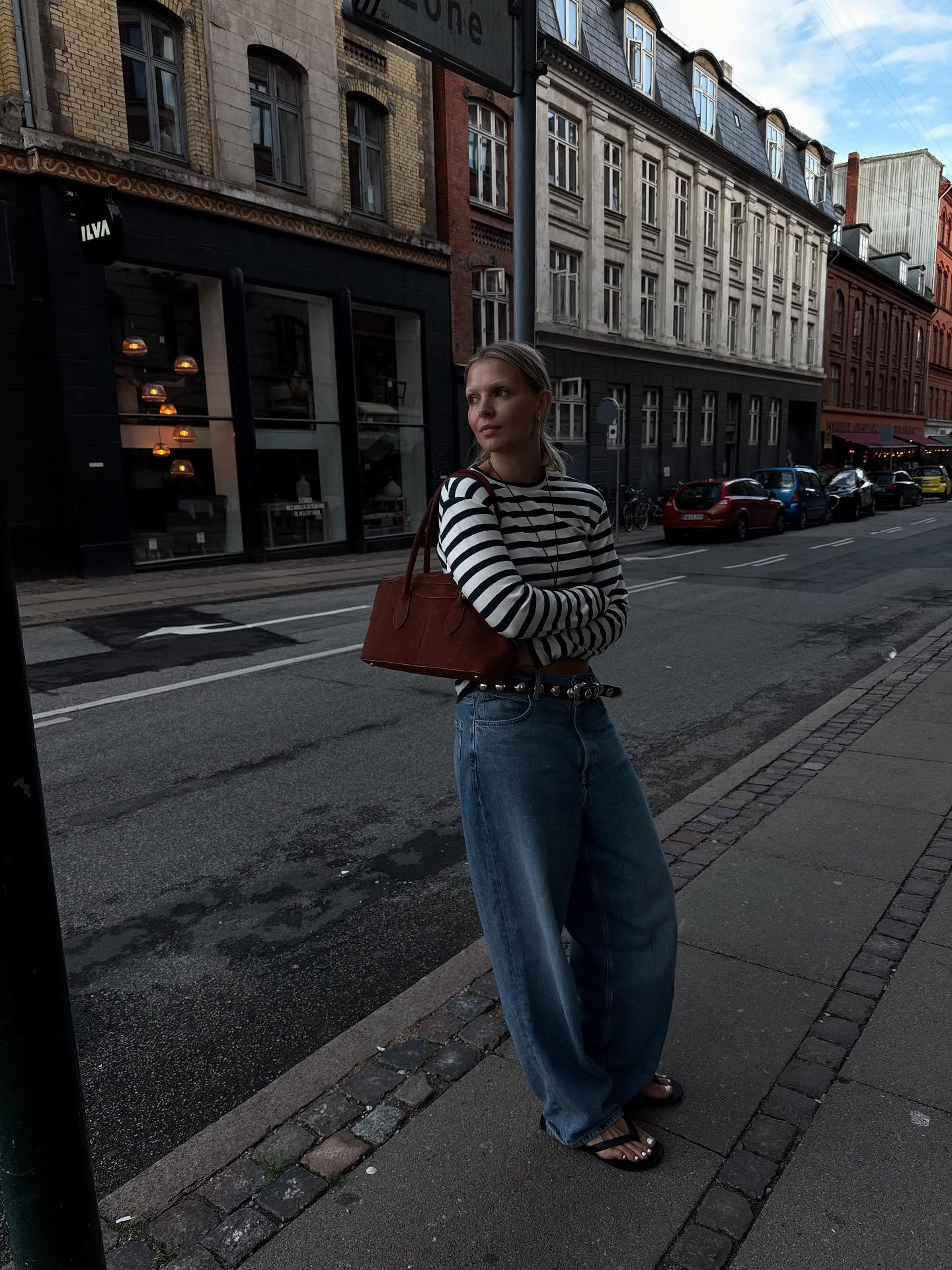 Hollie in a striped shirt, jeans and flip-flops
