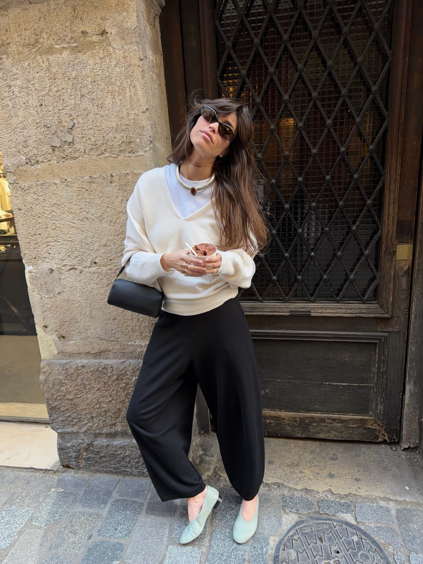 An image of @alisontoby wearing a v-neck knit, cropped trousers, micro pumps and The Row's '90s bags.