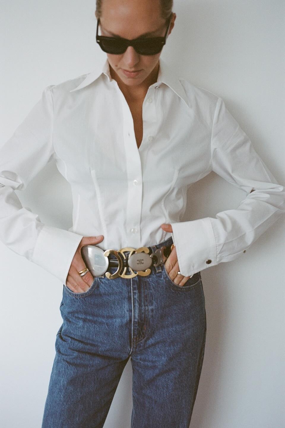 An image of @felicity.alice.brand wearing the Celine multi-buckle signature belt with a white shirt and blue jeans.